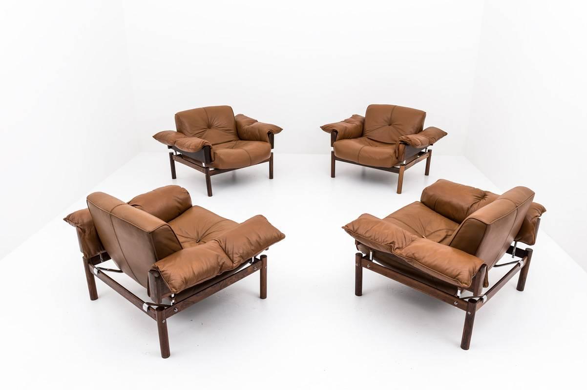 A set of four lounge chairs by Percival Lafér, Brazil
These chairs consist of a rosewood frame upon which the cushions rest. The cushions are upholstered in brown leather with buttons of rosewood on the seating and backrest. The armrests are held