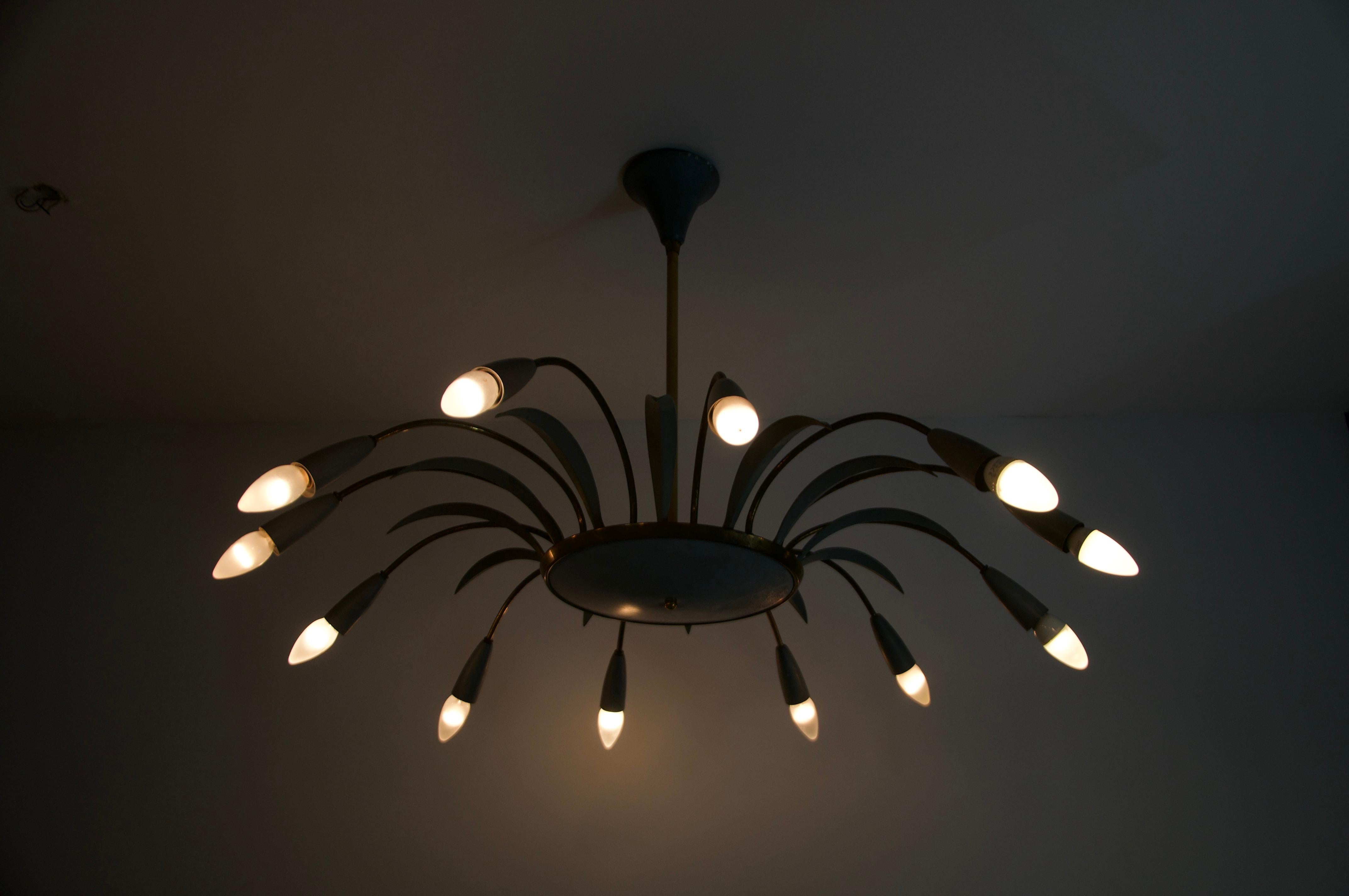 Questo straordinario lampadario Sputnik italiano degli anni '50 è un esempio straordinario di design moderno di metà secolo, che fonde l'ispirazione futuristica con una raffinata maestria artigianale. Il lampadario presenta un'elegante struttura in