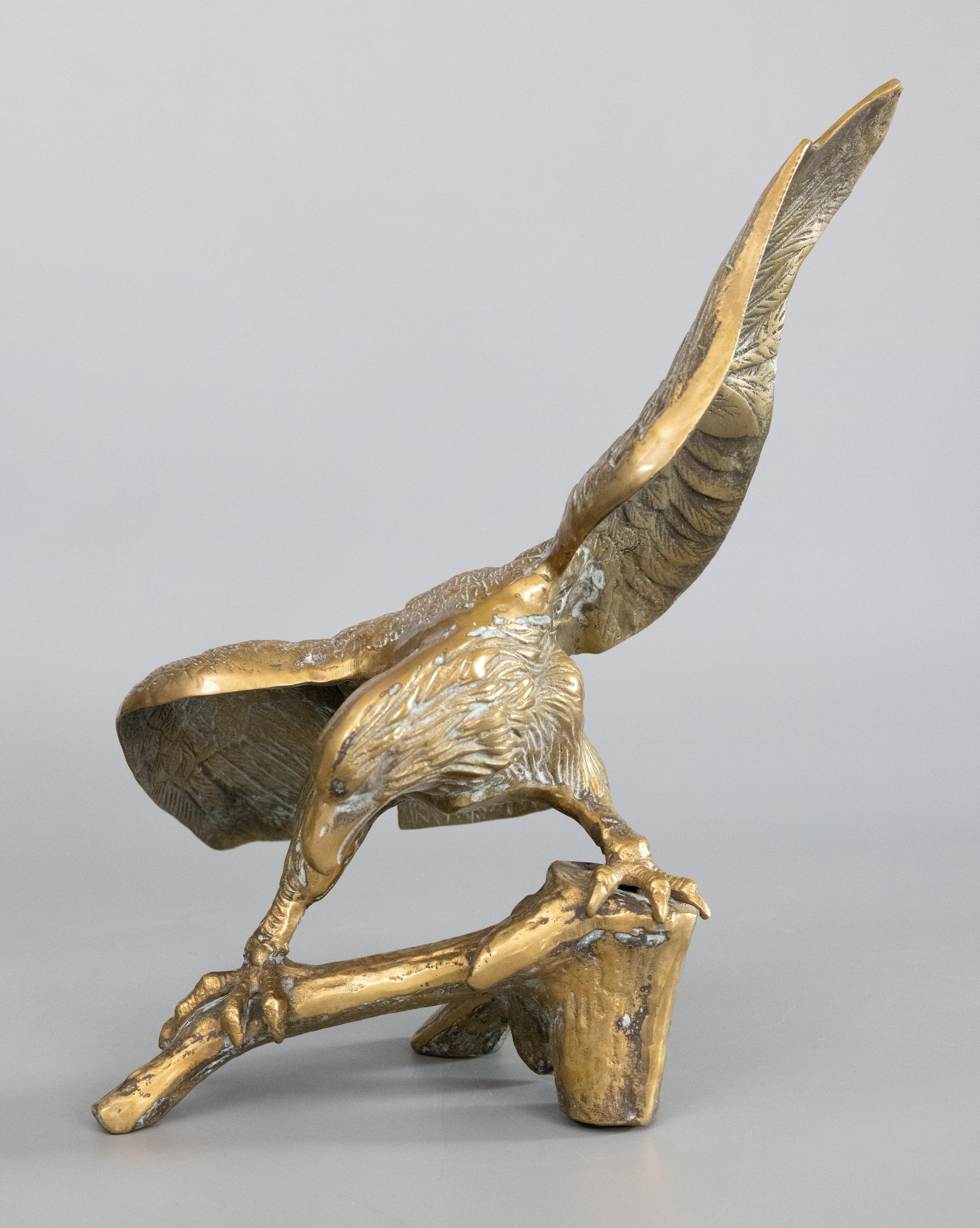 A superb mid-century Federal style American brass bald eagle sculpture perched on a tree branch with outstretched wings. This fine quality sculpture is large and heavy with wonderful details and a lovely aged patina. It would be a handsome addition