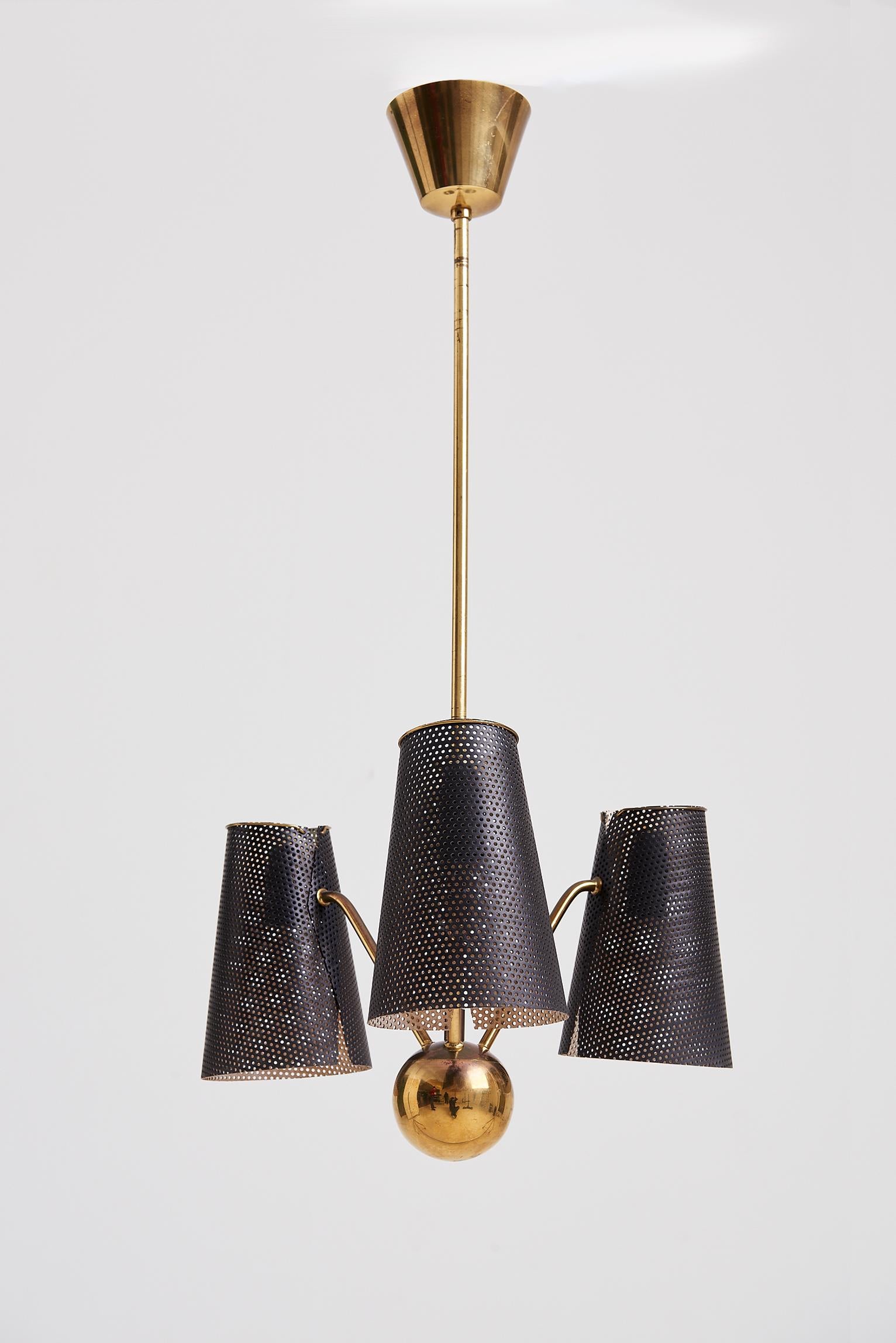 A brass and perforated black enamelled iron rigitule three-armed ceiling light,
France, Circa 1955.