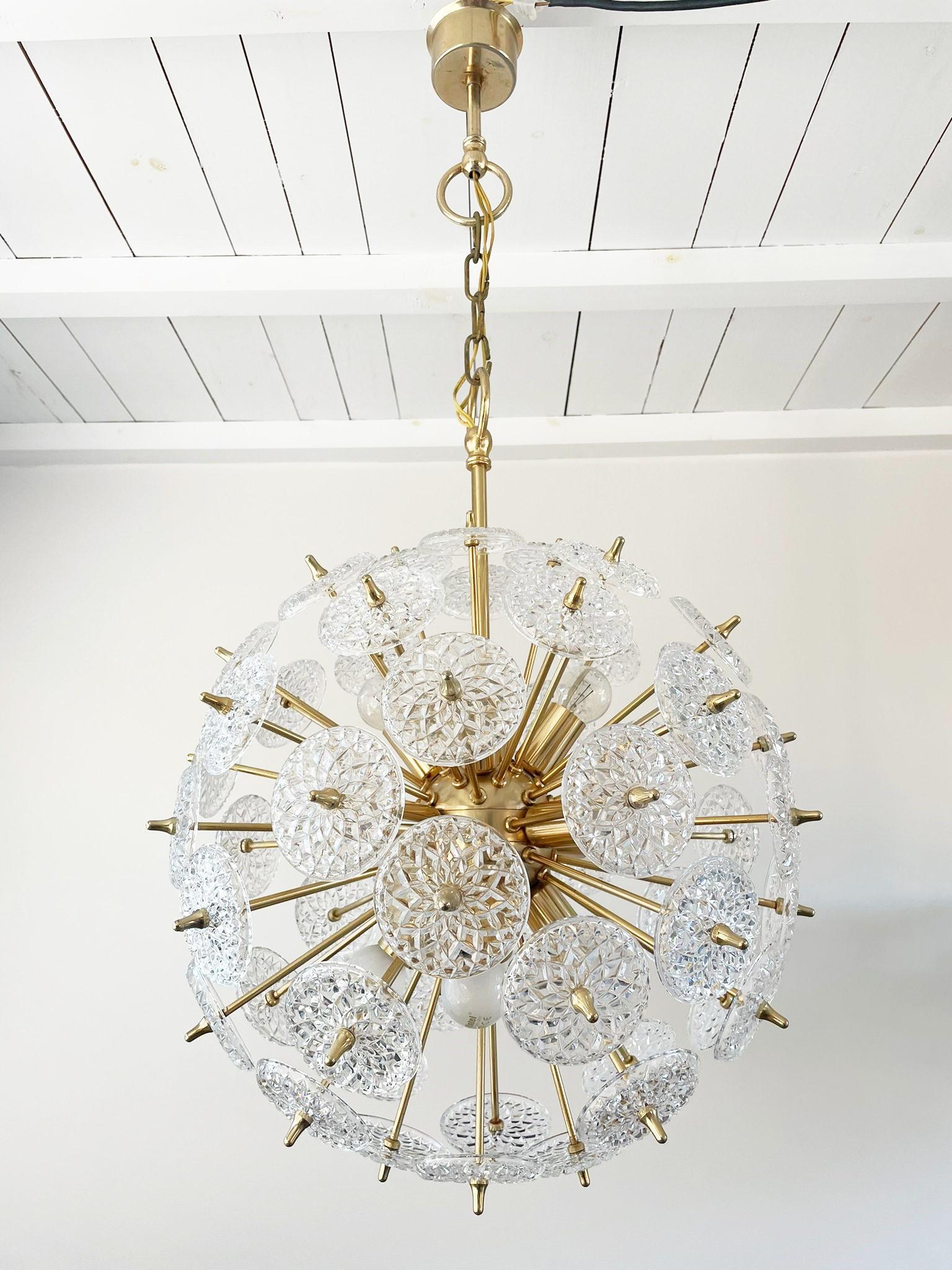 Impressive brass and crystal sputnik chandelier.

The crystals are made by the renowned belgium glass company Val Saint Lambert.

The chandelier has 12 lightpoints that can be used with regular E14 candle light bulbs.

These chandeliers are
