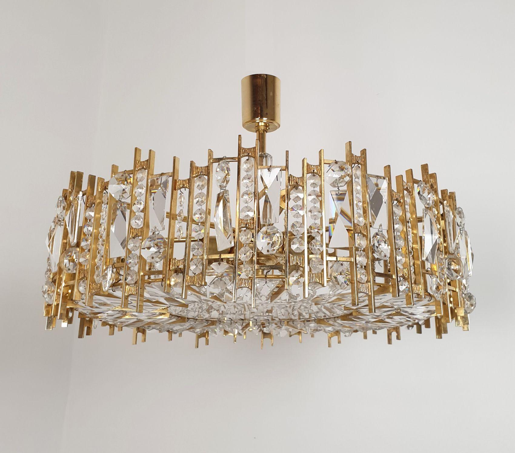 Mid-Century crystals chandelier attributed to Palwa, Germany 1960s.
The chandelier is made of Bohemian crystals, brass and bronze sculpted mounts.
The Mid Century chandelier has 7 lights and is professionally rewired for the US, with Candelabra or