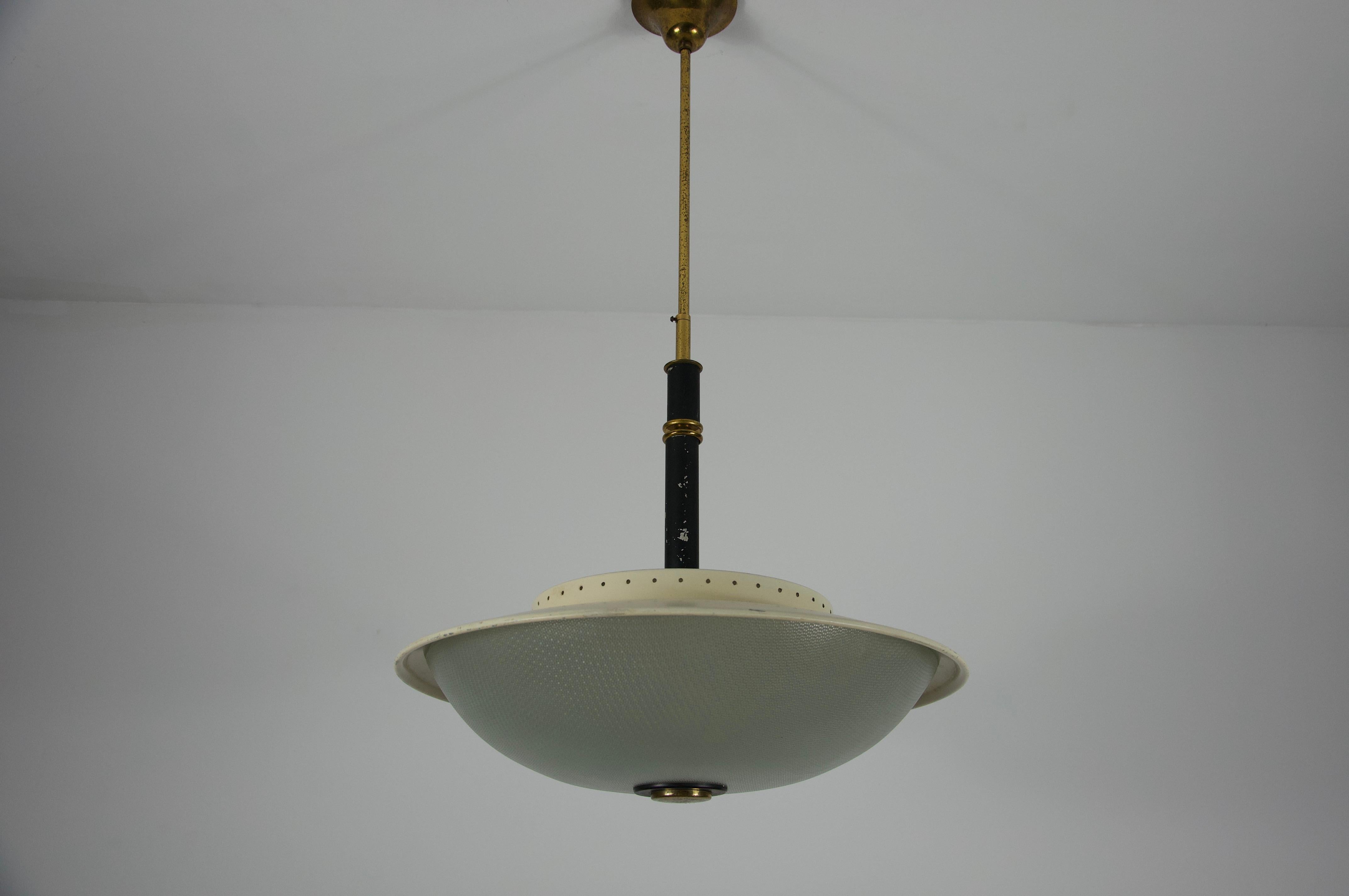 This stunning Mid-Century Ceiling Lamp by Stilnovo, crafted in Italy during the 1960s, is a superb example of Italian modernist design. The lamp features a distinctive, wide glass diffuser with a subtly textured or perforated surface, providing a