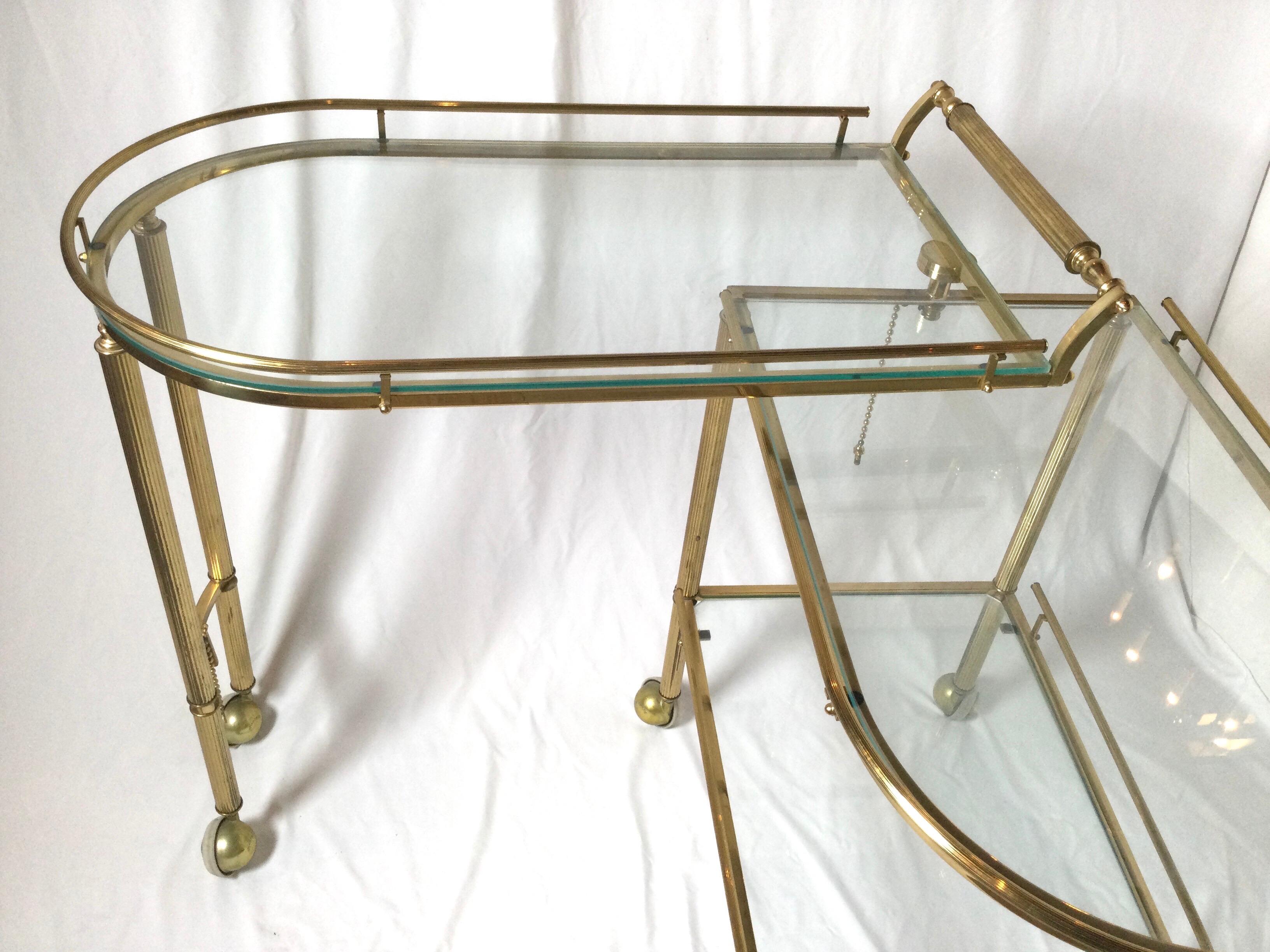 Midcentury brass and glass Italian swing out bar cart. This is a great piece for every day and party. You can have it closed for every day and open it up for those bigger events. Three glass shelves and the bottom section swings out. Nice ball wheel