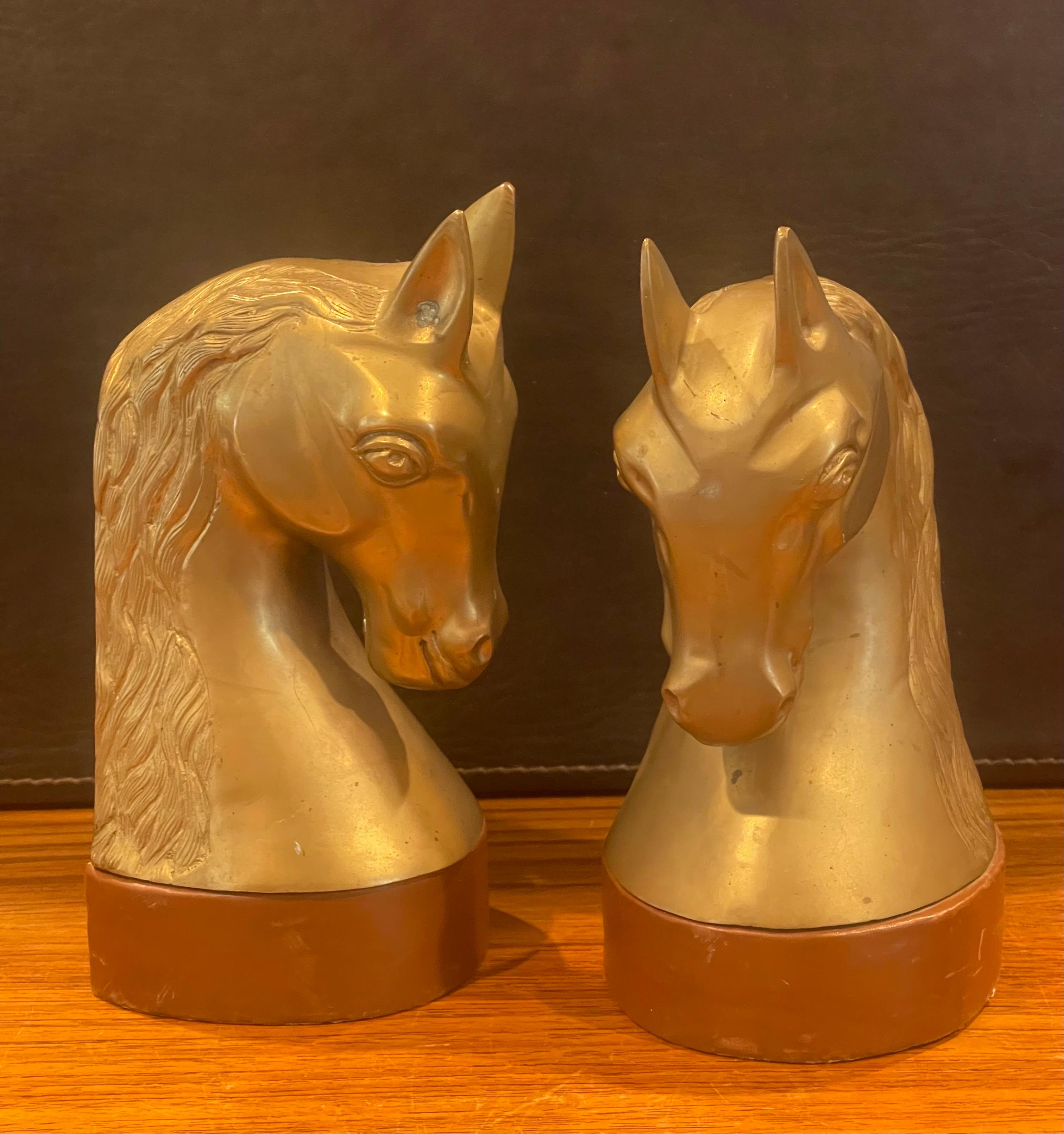 Striking pair of vintage brass and leather horse head bookends, circa 1970s. The bookends are in good vintage condition with a beautiful patina and measure 8.25