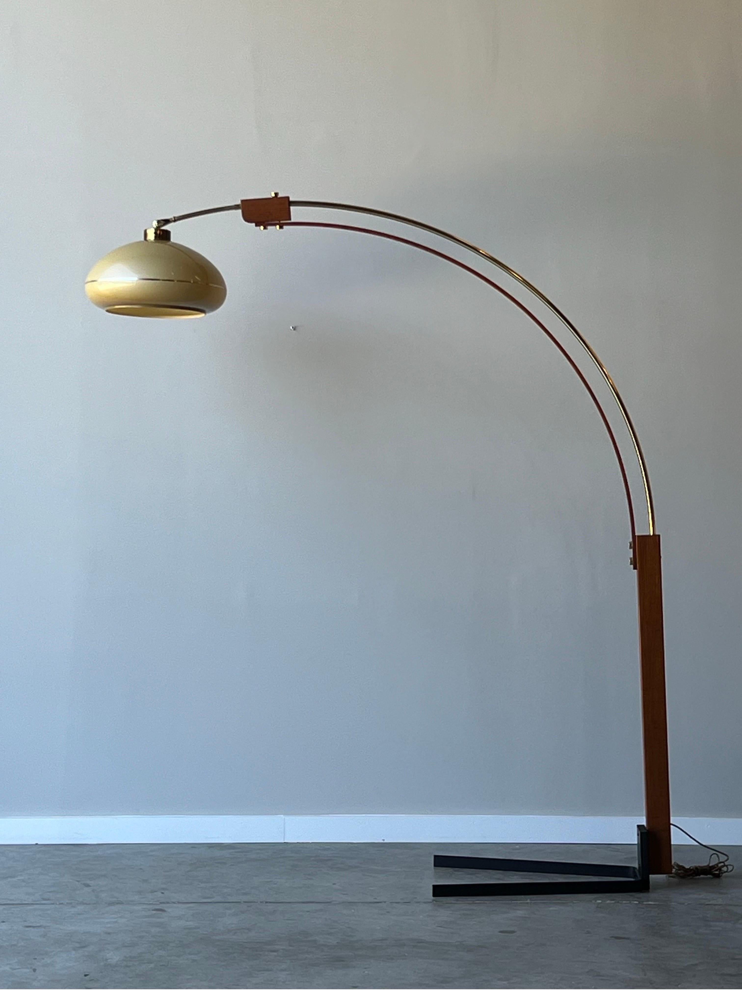 Mid-century arc floor lamp designed by Nova of California. This arc is extremely unique regarding the materials used. Bentwood oak gives a warmth in addition to the brass accents. The lamp sits on a slender black metal u-shaped base. The shade is