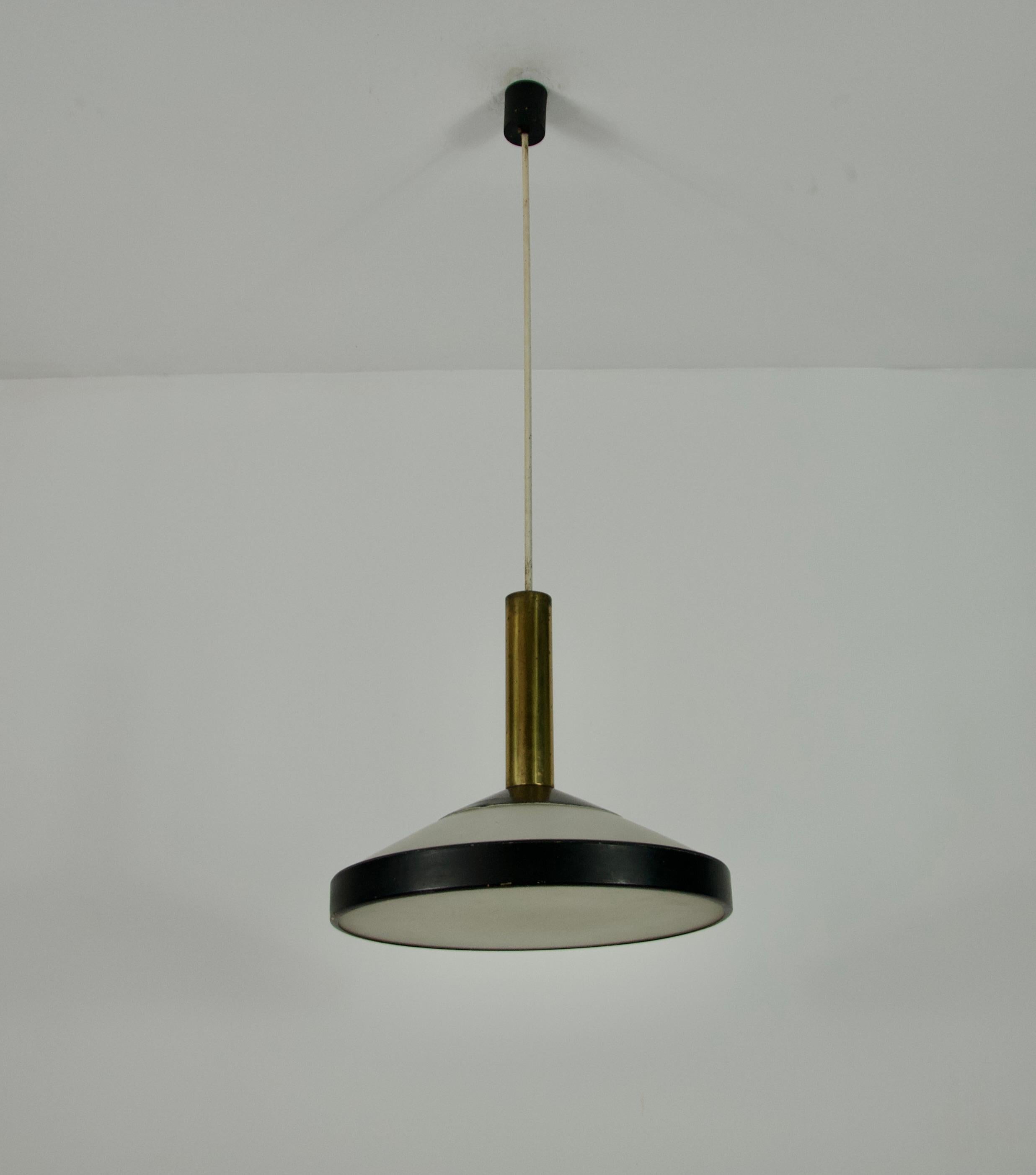 Questa iconica lampada da soffitto del Mid-Century, progettata da Stilnovo in Italia negli anni '60, presenta una silhouette elegante e minimalista che cattura l'essenza del design modernista. La lampada è composta da uno stelo cilindrico in ottone
