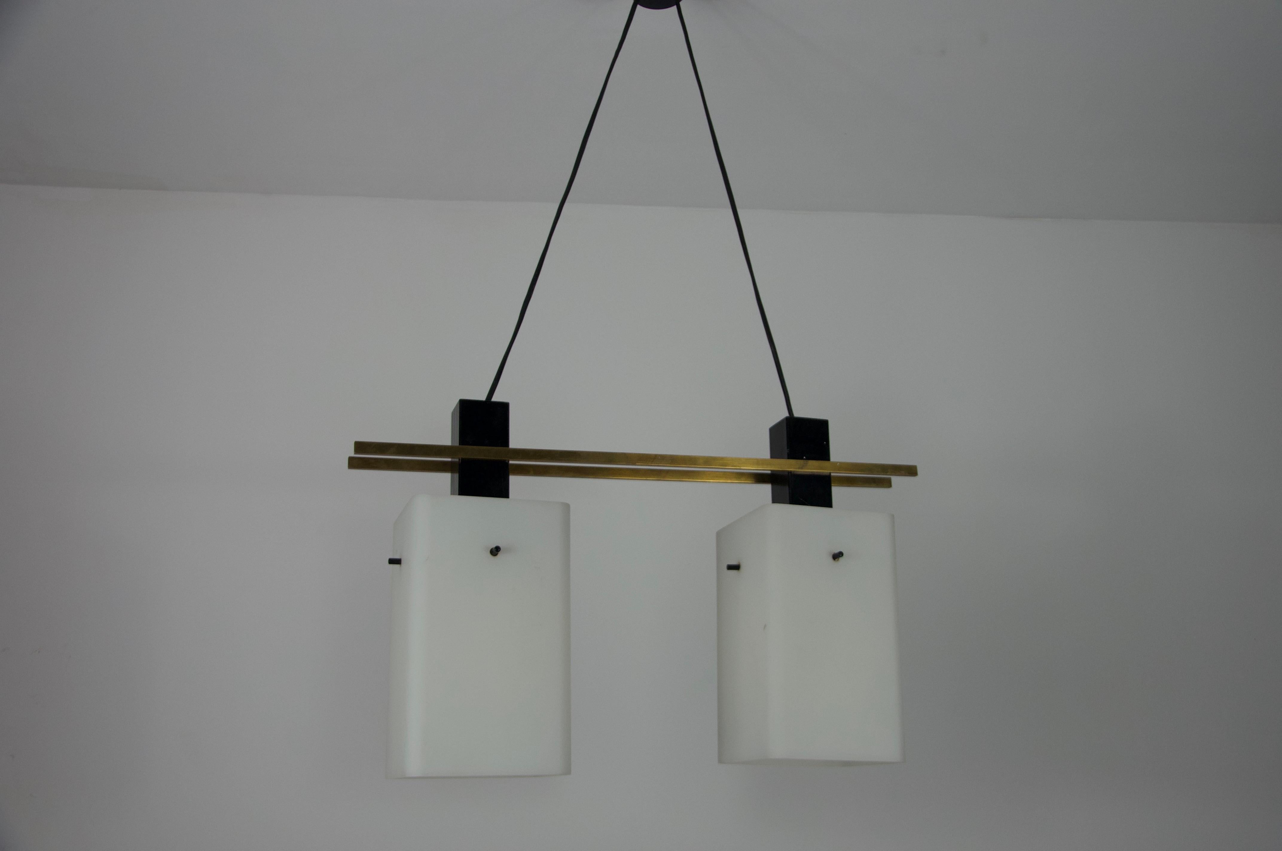 Diese exquisite, von Stilnovo in den 1960er Jahren entworfene Pendelleuchte ist ein bemerkenswertes Beispiel für das moderne italienische Design der Jahrhundertmitte. Die aus hochwertigem Messing und Opalglas gefertigte Leuchte bietet ein perfektes