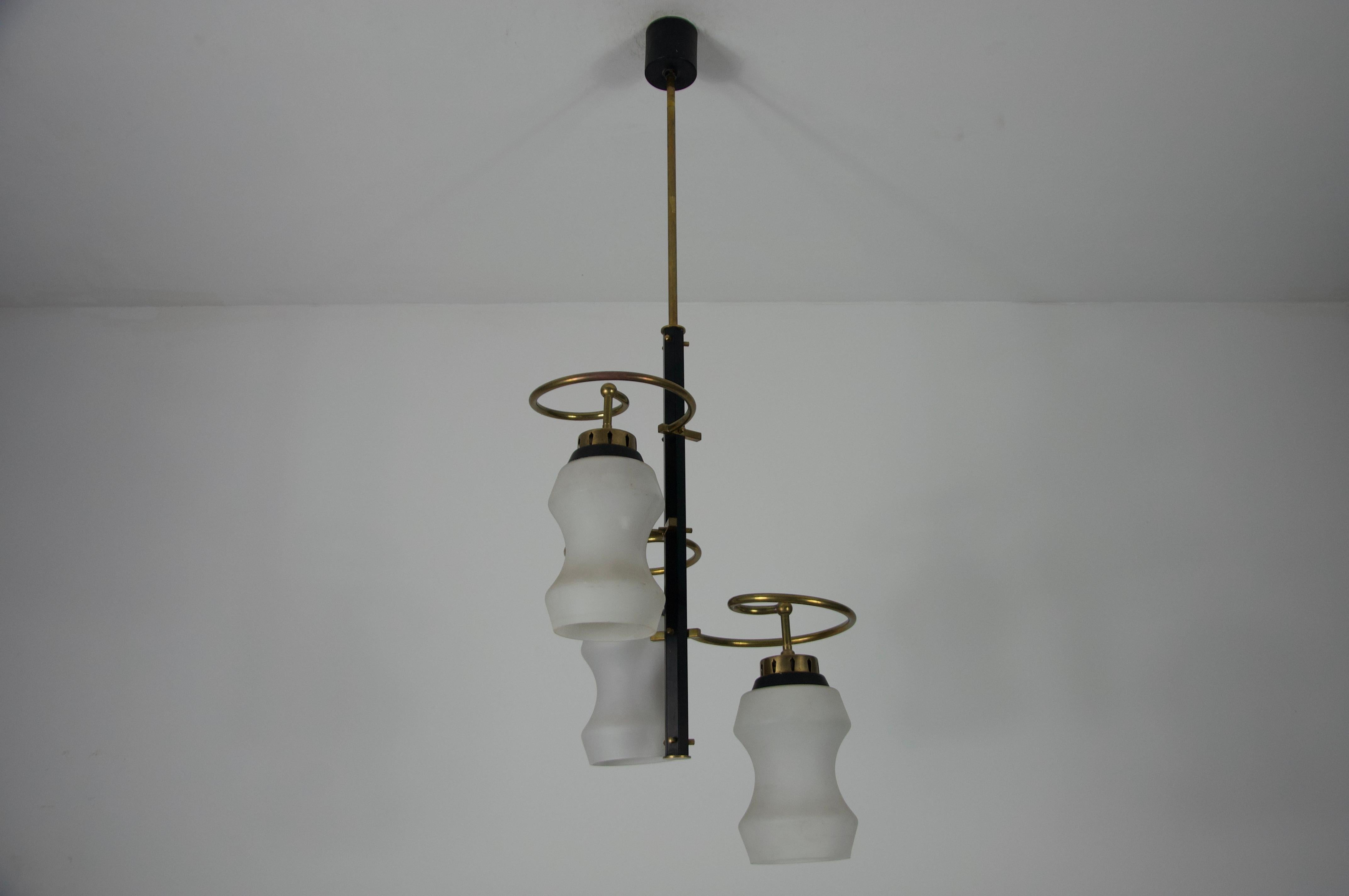 Questa elegante lampada da soffitto è stata realizzata in Italia negli anni '60 e mette in mostra l'estetica raffinata del design moderno di metà secolo. Il pezzo è caratterizzato da tre scultorei paralumi in vetro opalino con silhouette