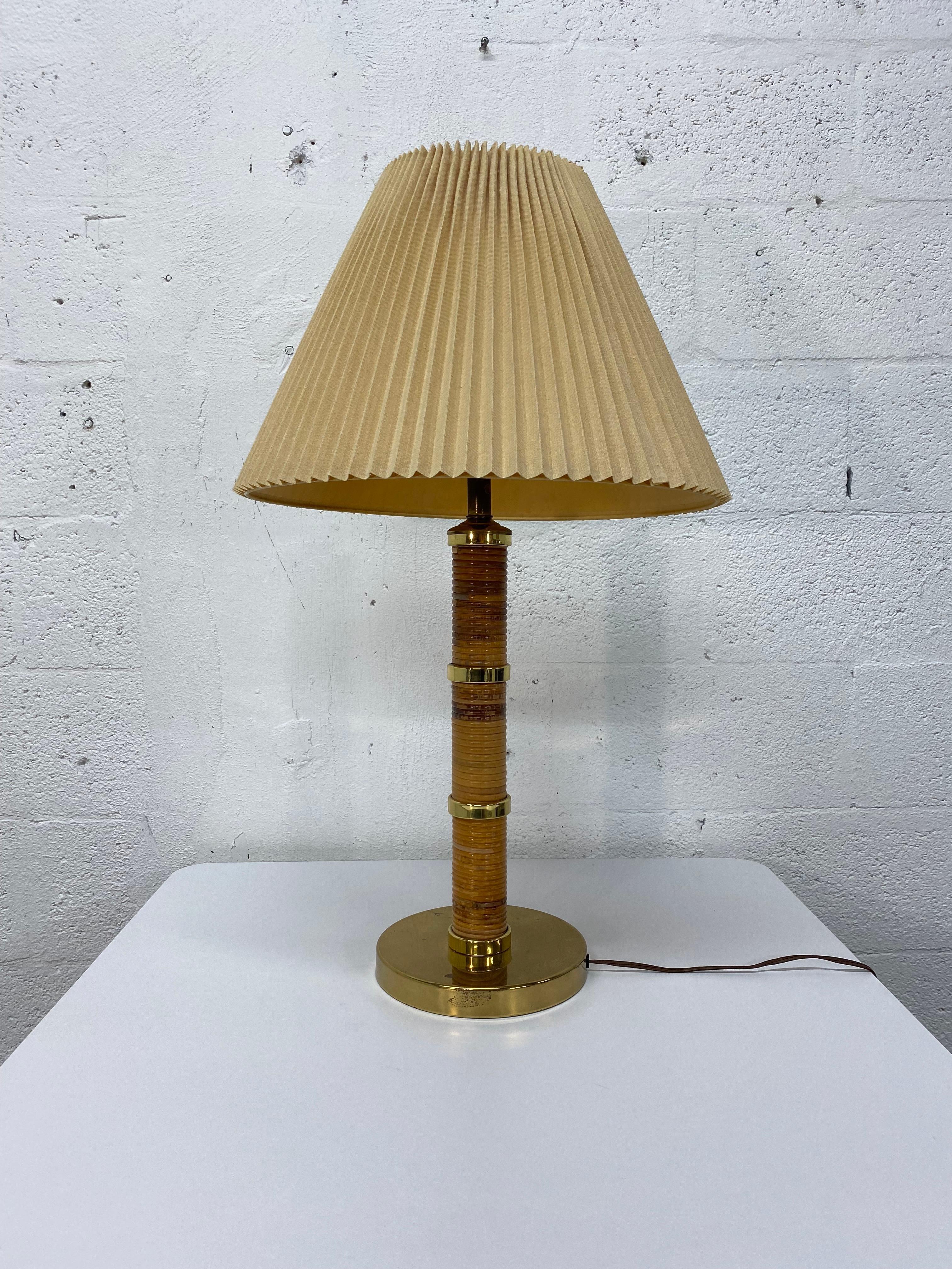 Original 1970s brass table lamp wrapped in rattan with a beige ribbed lamp shade.