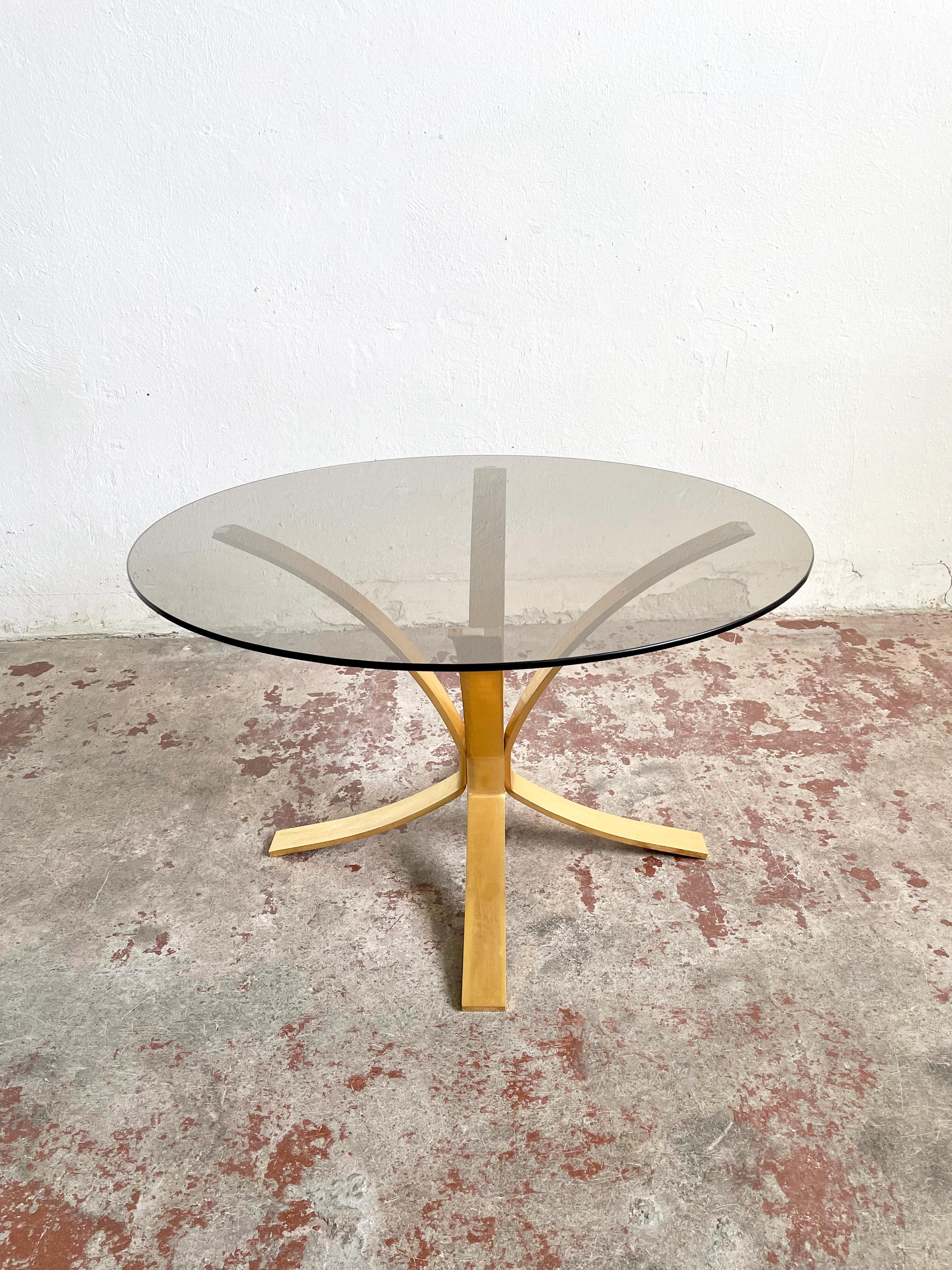 Mid-century coffee table with a heavy brass base in gold color and a round-shaped smoked glass tabletop

Condition: very good vintage condition with small traces of cosmetic wear and vintage patina

Size: 48 x 80 x 80 (H/W/D).