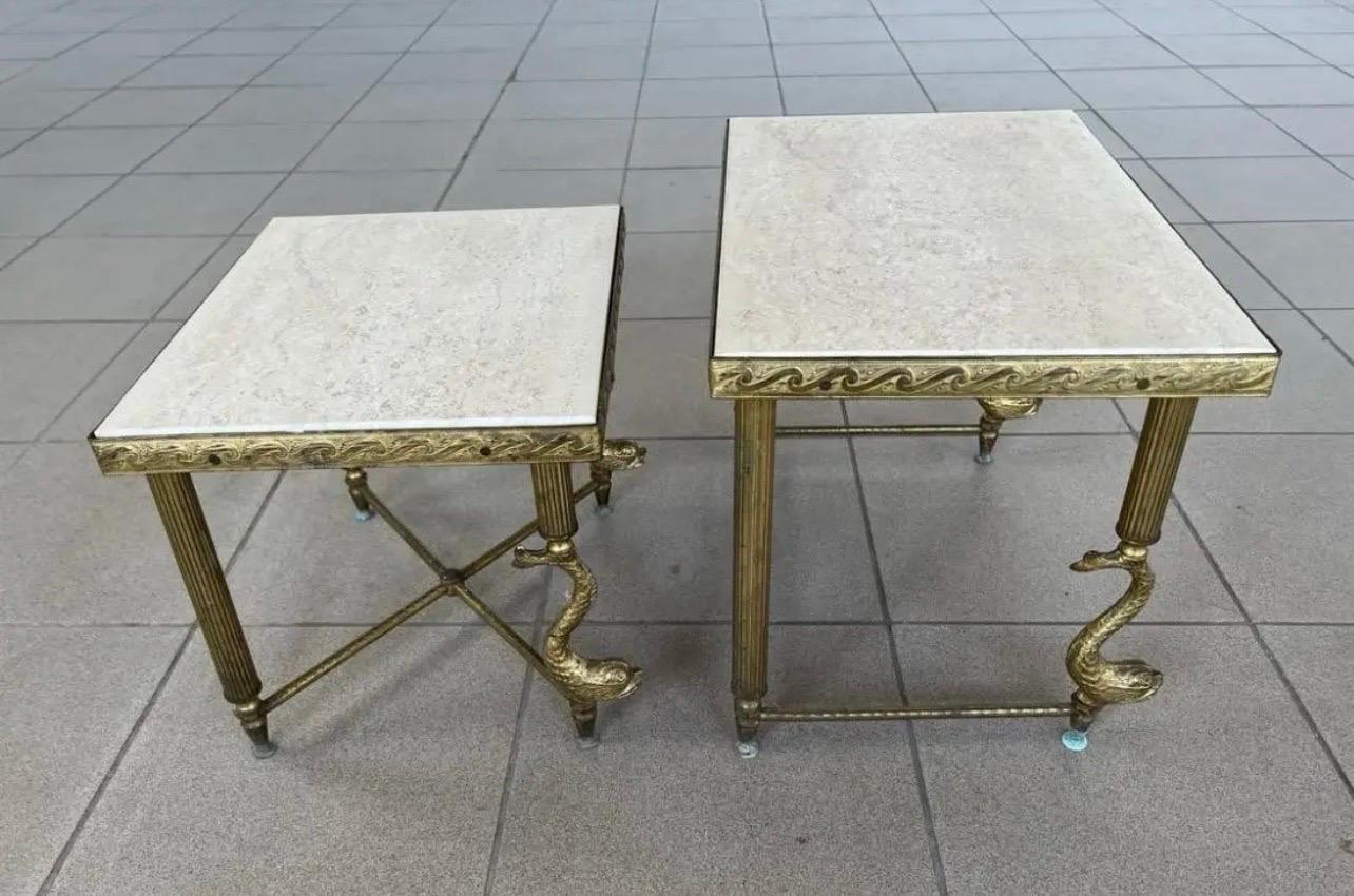 Mid Century Hollywood Regency nesting end tables with stone tops and reeded column style brass legs with carved brass dolphin figures.  Two pieces in all featuring differing heights and frames.  Dimensions as follows:
Small,  H 12