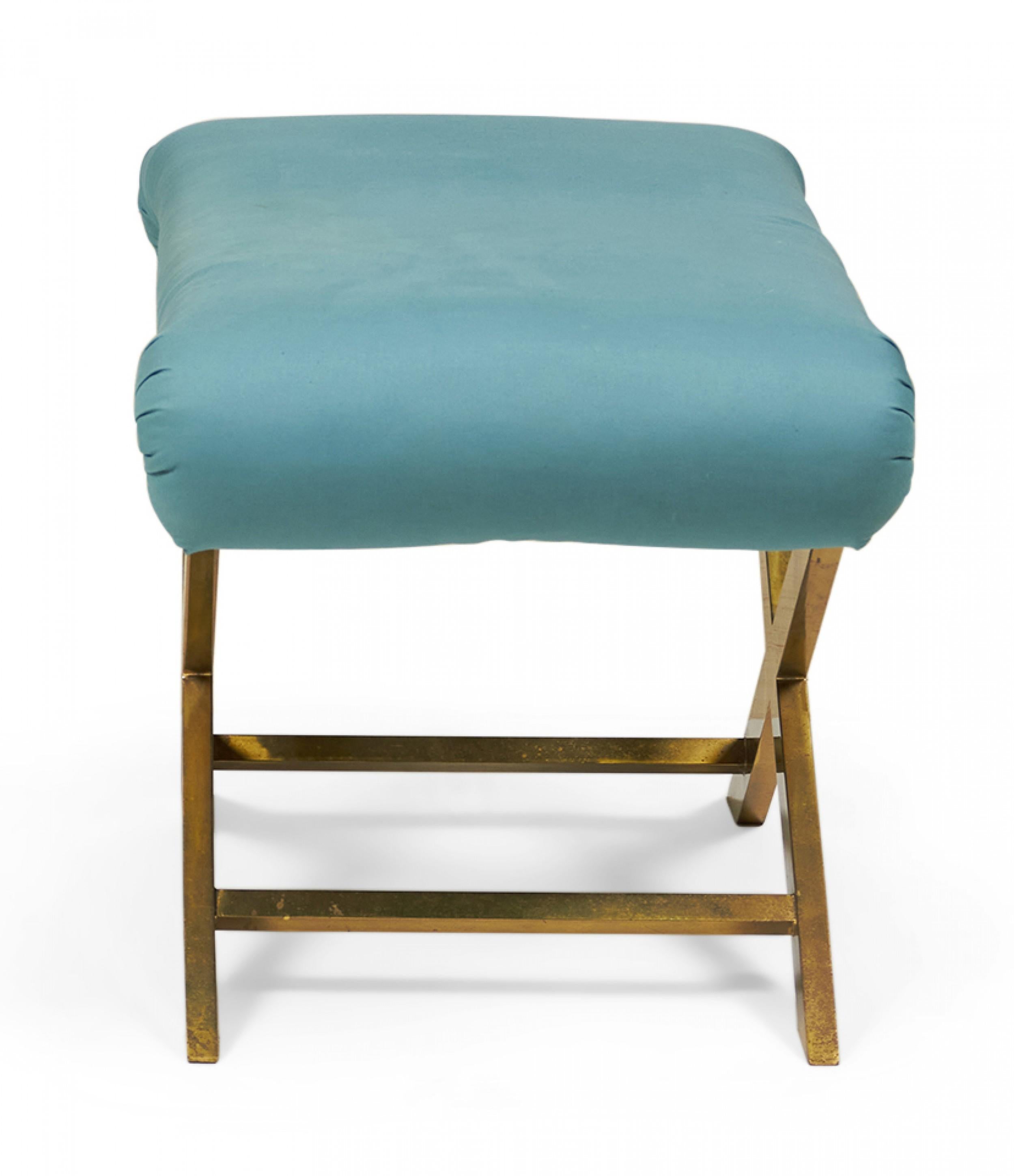 Mid-century x-bench with a brass frame topped with a teal cotton upholstered seat.
 
