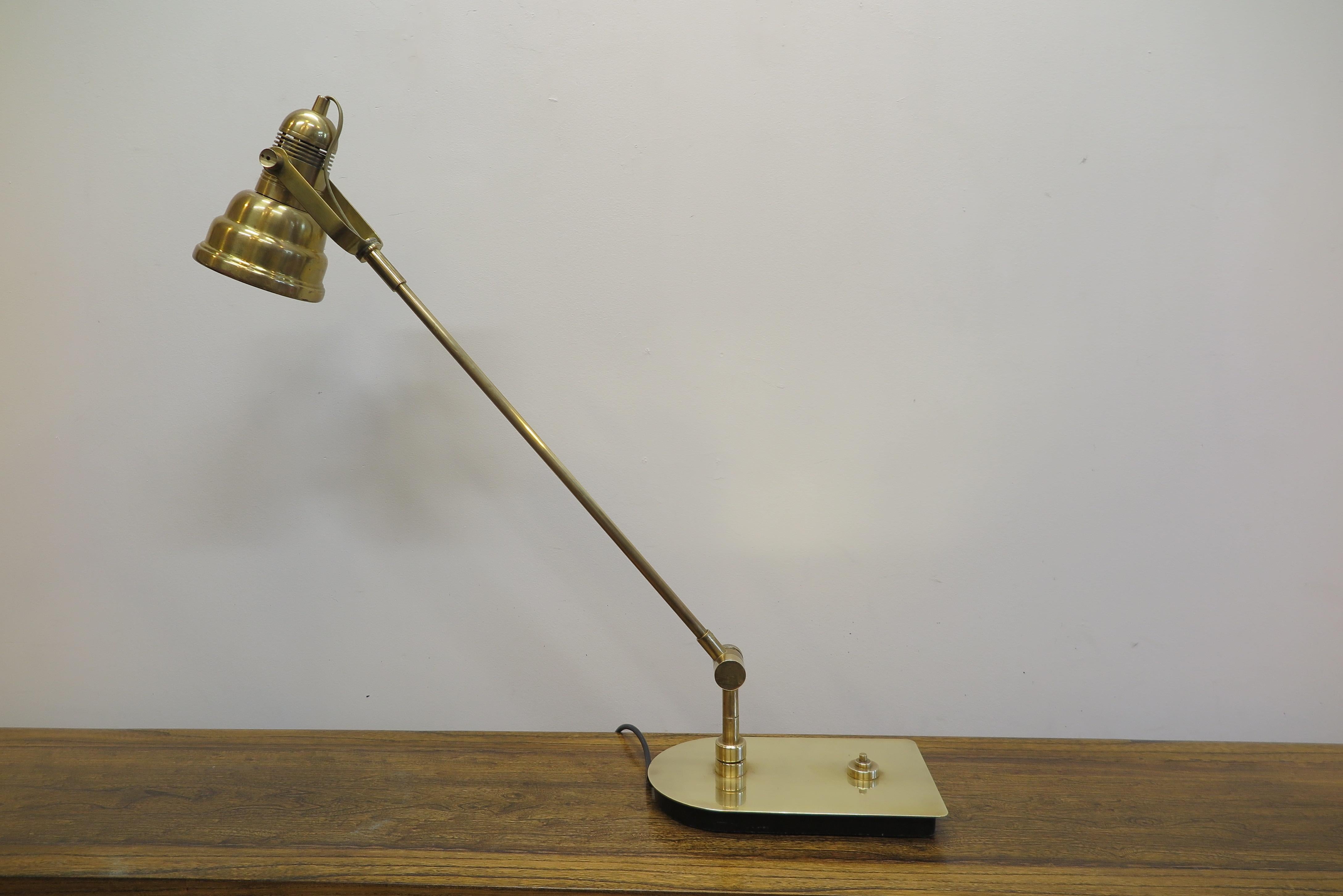 Midcentury brass articulating table lamp having a brass shade. Arm moves 180 degrees from front to back of base and can swing to the left side or right side 45 degrees. The shade having also 180 degree movement with the ability to provide upward or