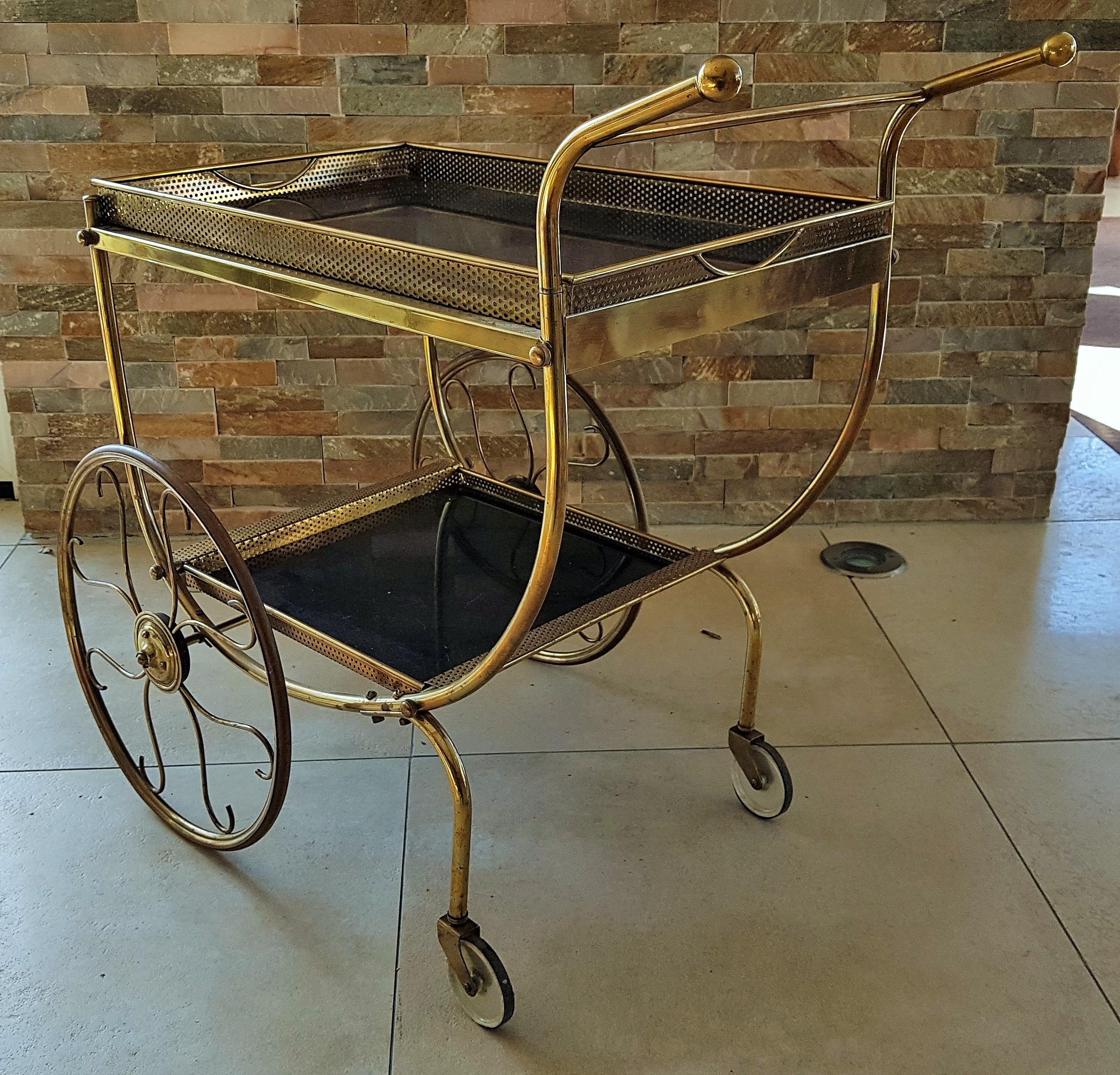 Midcentury brass bar cart by Josef Frank for manufacturer Svenskt Tenn, Sweden, 1950s

Made of tubular and perforated brass. Black tin tabletops. Trays removable. Great unrestored original vintage condition.

