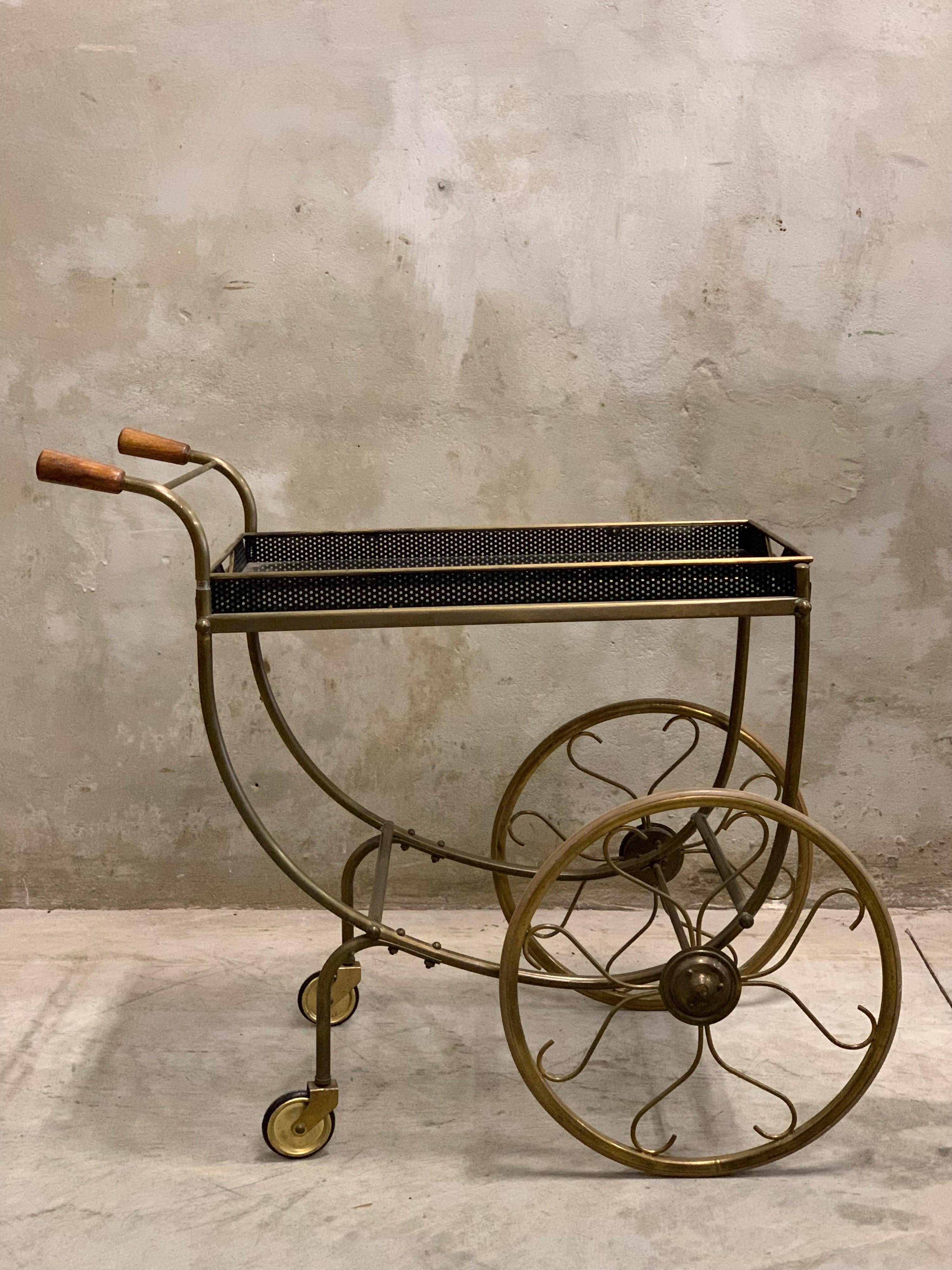 Beautiful trolley made in the 1940s/50s by Svenskt Tenn Sweden. All copper with metal tray. Great big wheels and has wooden handles. The perfect piece of furniture to display your beautiful bottles. The tray contains a glass plate, which you could