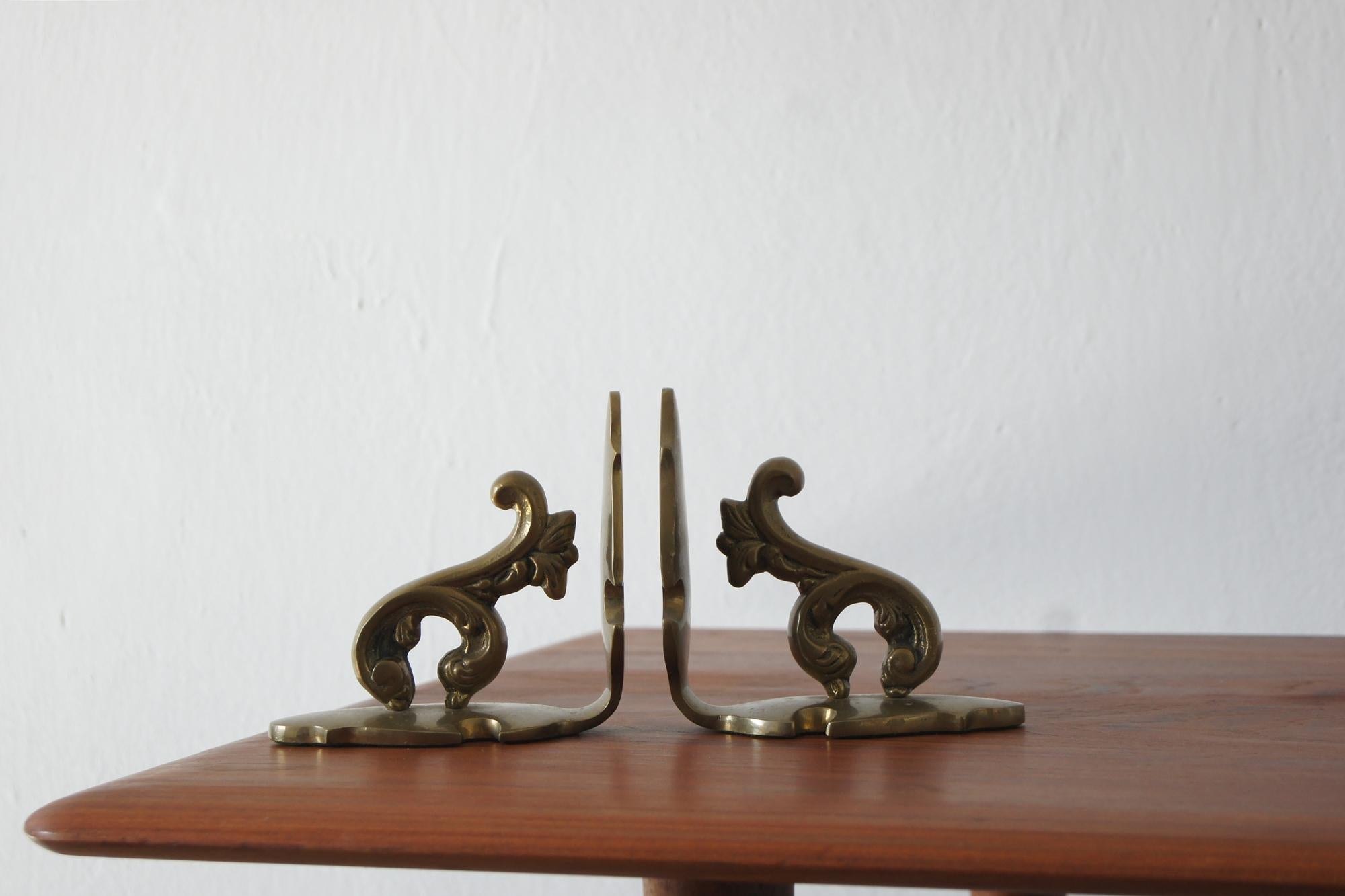 Un sofisticato set di due fermalibri in ottone degli anni '60. Questi pezzi robusti e decorativi sono realizzati in ottone pesante e lucido e sono ornati da un sottile motivo a foglie d'acanto, simbolo di eleganza e stile senza tempo.

Ogni