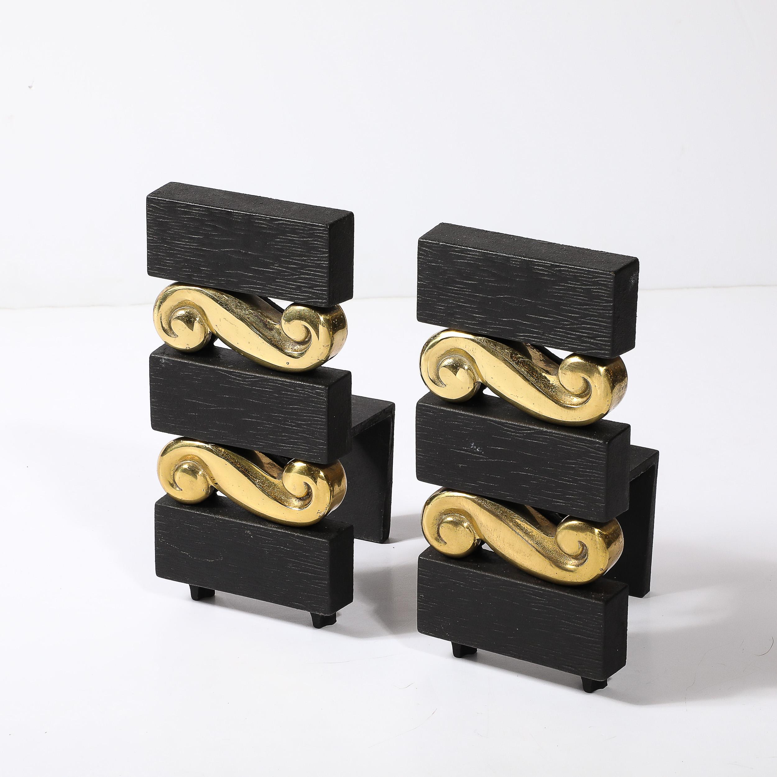 This unique and sophisticated Pair of Mid-Century Modernist Stacked Scroll form Andirons in Brass & Bronze W/ Faux Bois Textural Detailing by Donald Deskey for Bennet originates from the United States, Circa 1950. They feature a stacked composition