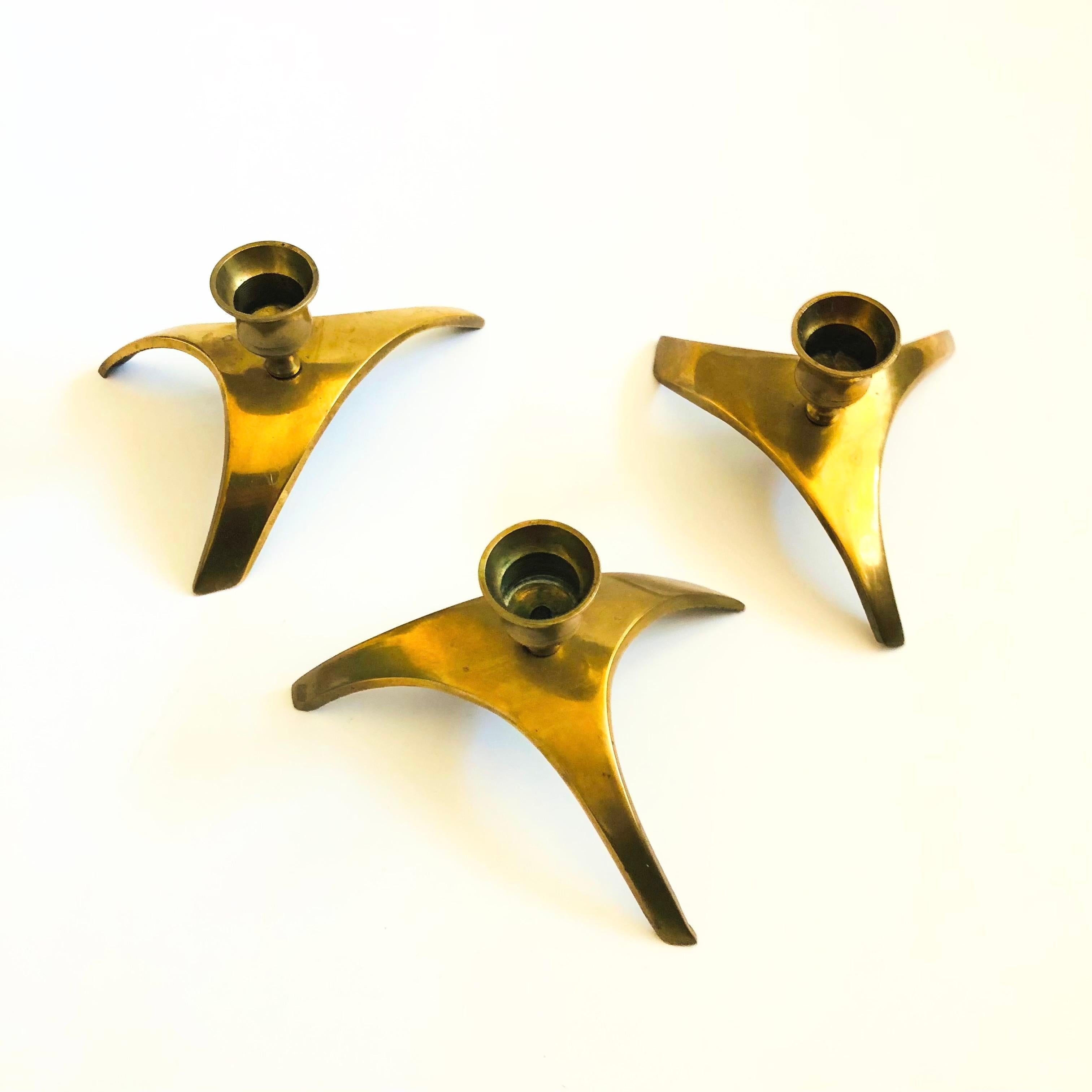 Un set di 3 portacandele in ottone della metà del secolo. Grande design atomico con basi a treppiede. MEAN è adatto a contenere candele standard.

