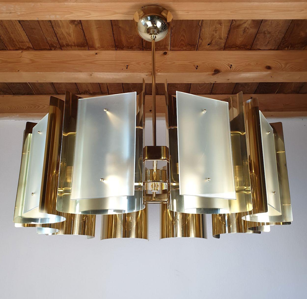 Large Mid Century Modern round brass chandelier, attributed to Sciolari Italy 1970s.
The vintage chandelier is made of ten curved polished brass elements and frosted glasses, each nesting one light.
The Brass chandelier has 10 lights and is