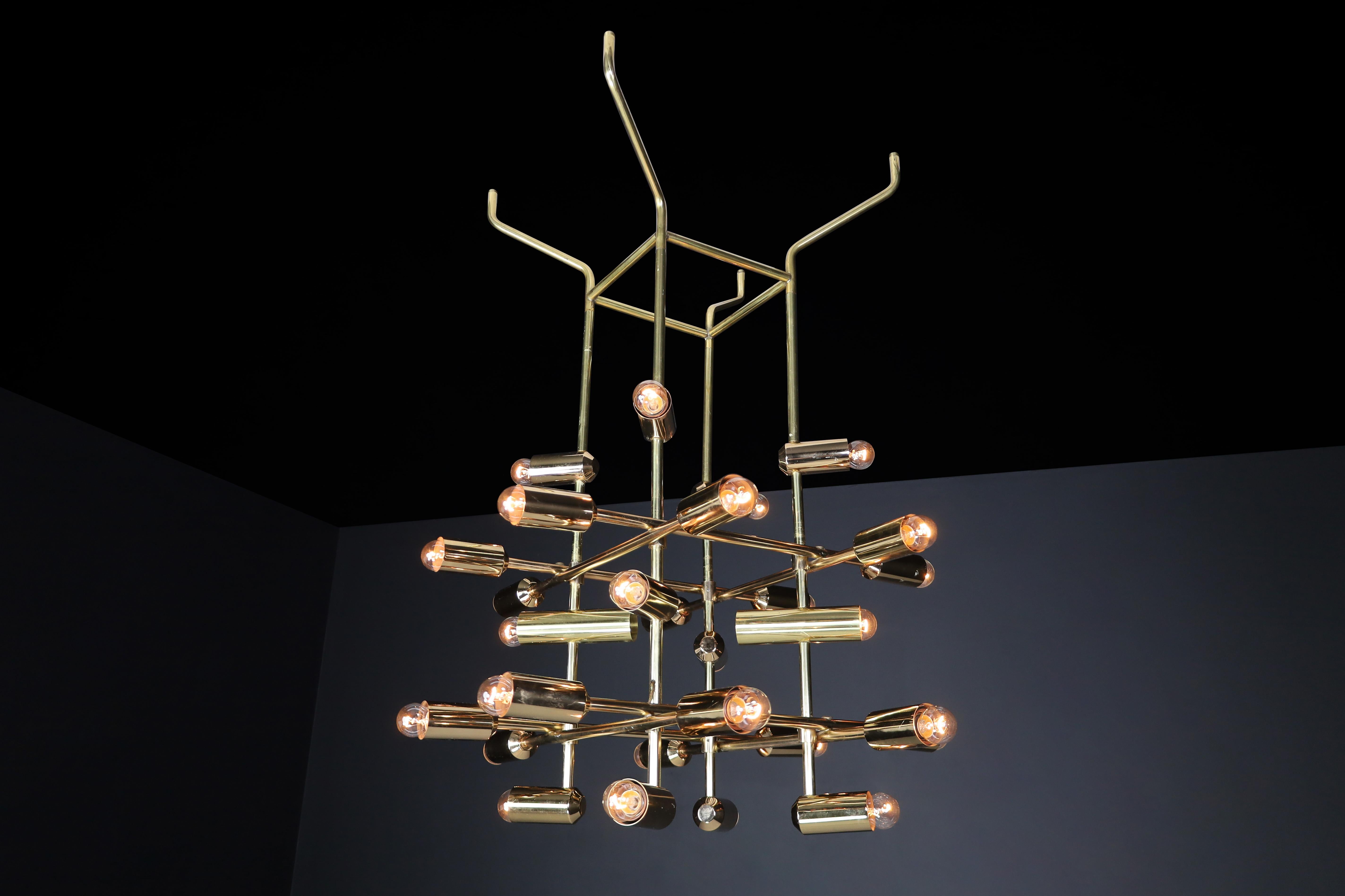 Mid-Century Brass Chandelier wit 28 lights, Switzerland 1960s.

A large mid-century chandelier made of brass was manufactured in Switzerland in the 1960s and is now available in Europe. The chandelier has a unique design consisting of a brass