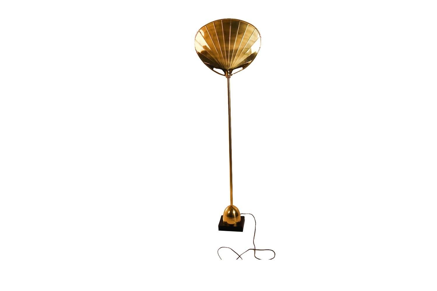 This is an absolutely extraordinary, palm leaf floor lamp by Chapman, superior craftsmanship, circa 1979. Features a tall slender brass column raised on a brass dome with a supporting ebonized plinth base. The stylish palm leaf shade provides subtle