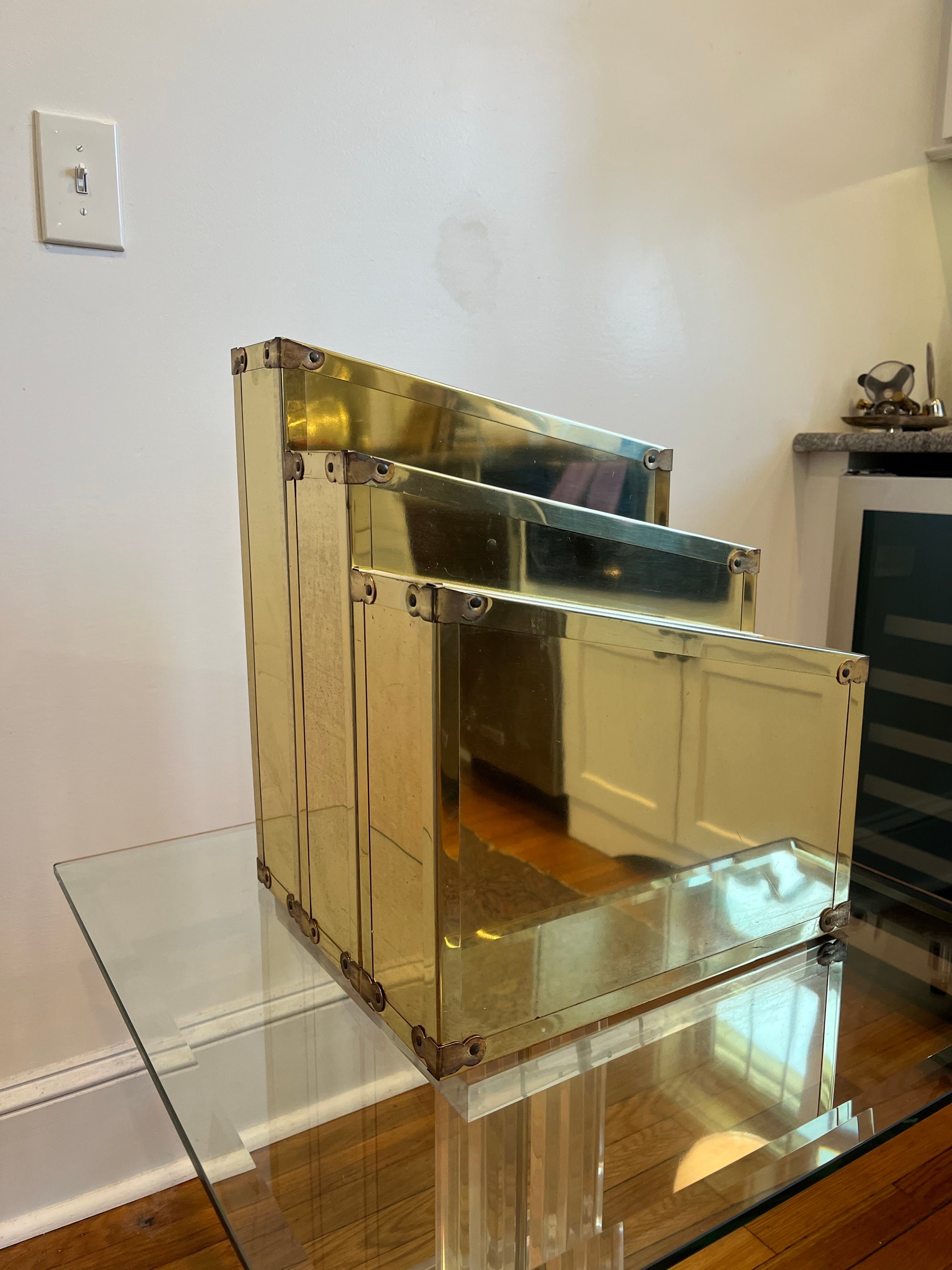 Superbe porte-revues en laiton avec un design Campaigner à la manière de Sarreid. De superbes visuels avec un design de gratte-ciel. 3 zones de stockage inclinées offrent des expositions variées. 
