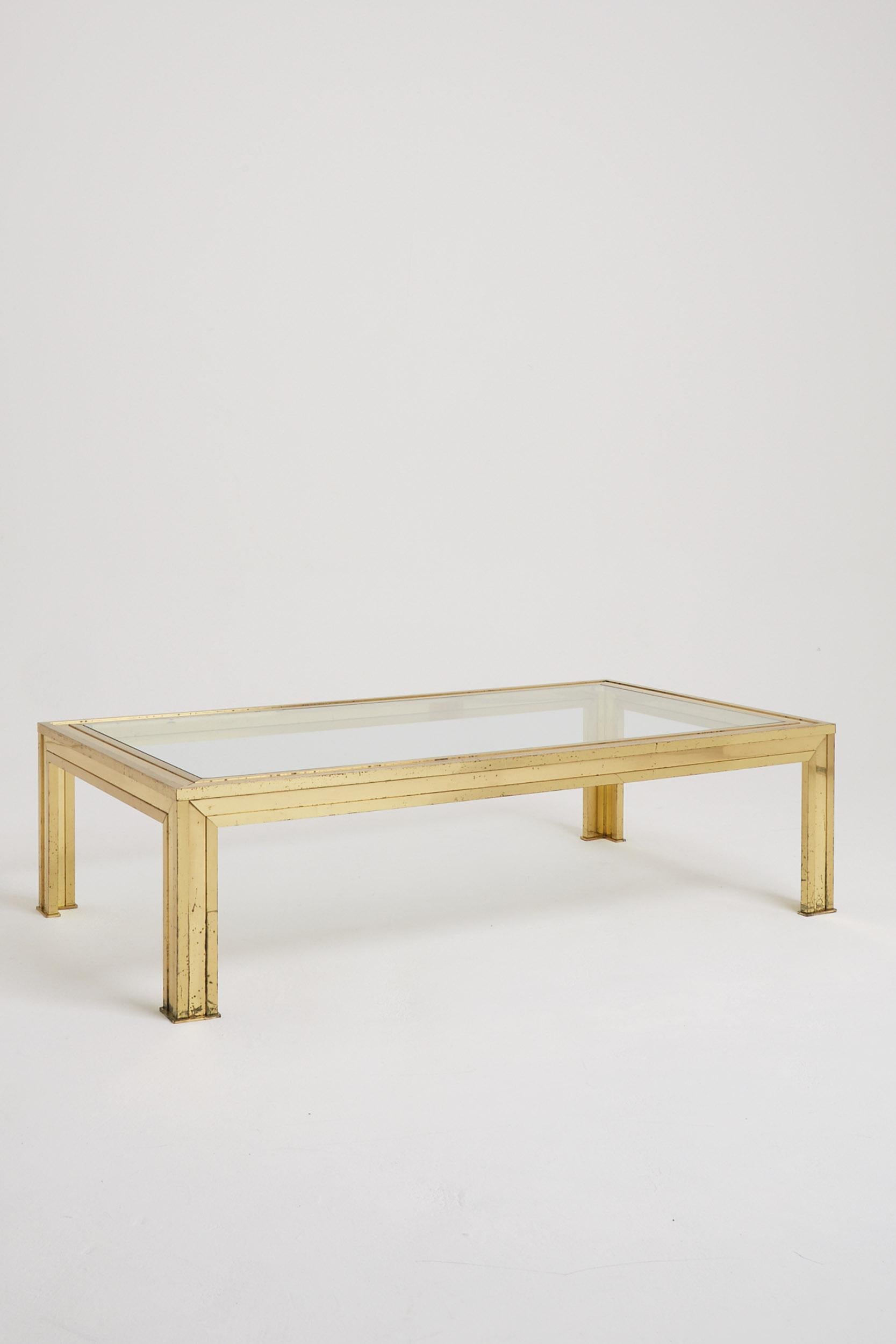 A large brass and glass top coffee table
France, Circa 1970.