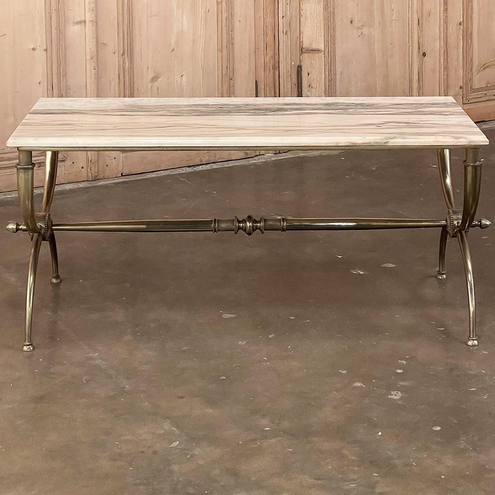 Midcentury brass coffee table with marble top is the essence of refined elegance with a distinctive style flair yet not too ostentatious. One first notices the beautifully veined slab of marble that has been selected as the top, cut with a cove