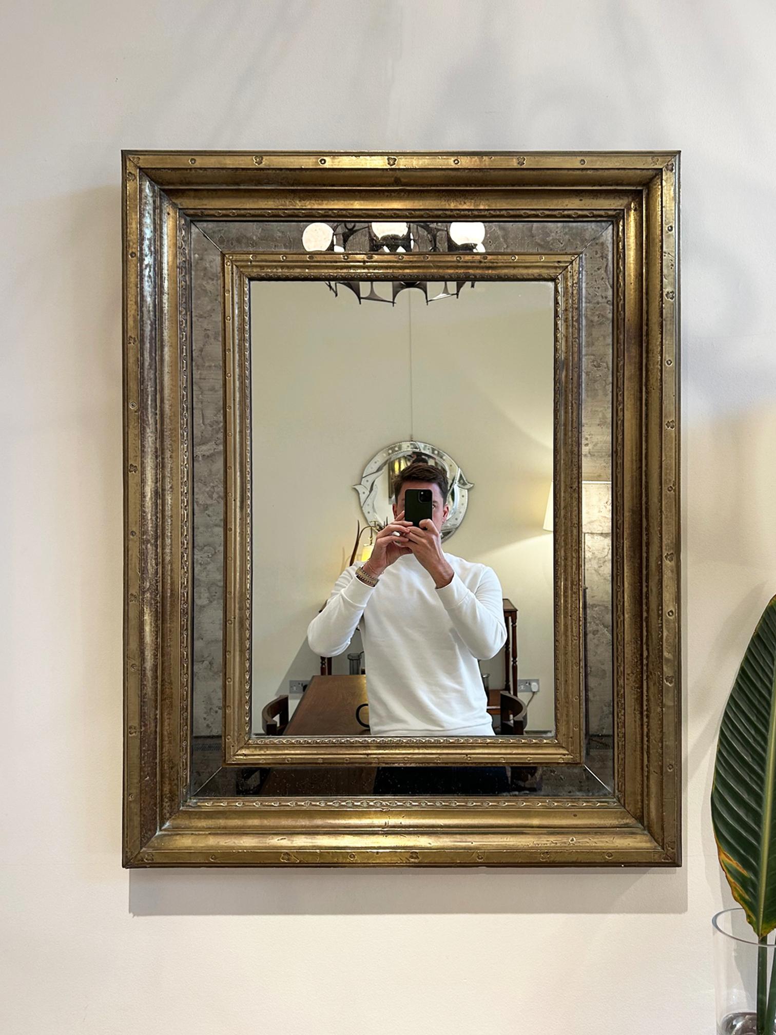 A brass cushioned mirror, possibly by Rodolfo Dubarry
Spain, 1970s
91 cm high by 70 cm wide by 6 cm depth
