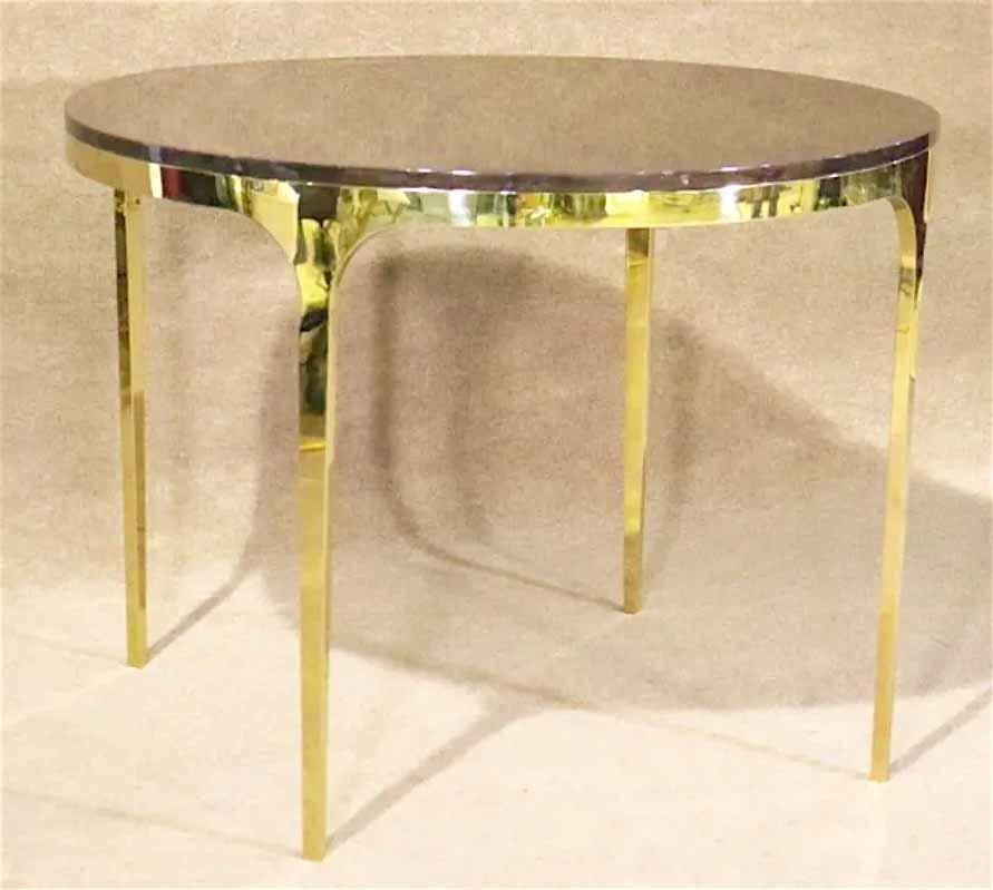 Round dining table with polished brass base. Wood veneer top complimented by long slender brass legs.
Please confirm location.
