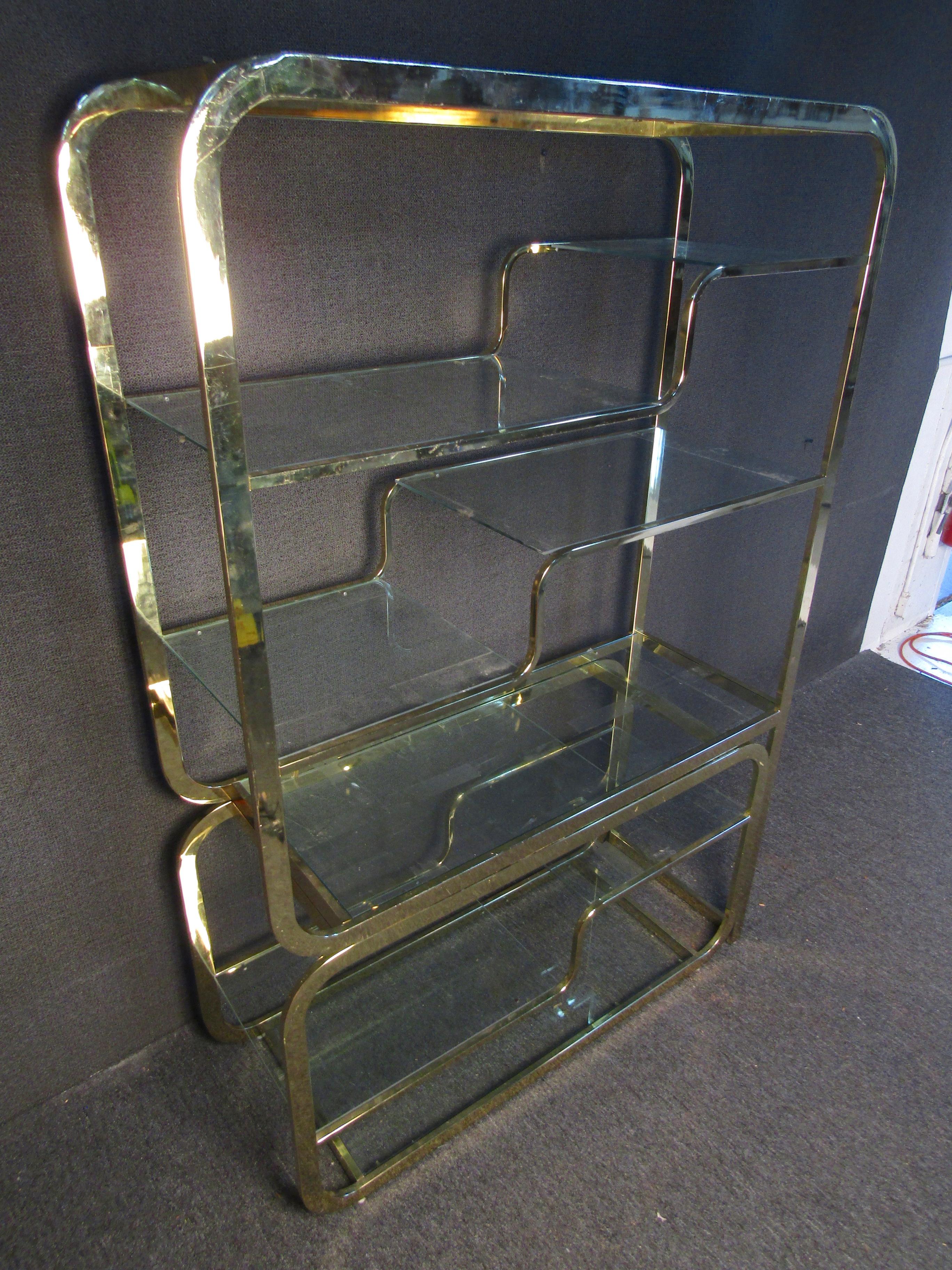 Mid-Century Modern bookcase with sliding base. Brass frame and glass shelving.
(Please confirm item location - NY or NJ - with dealer).
 
