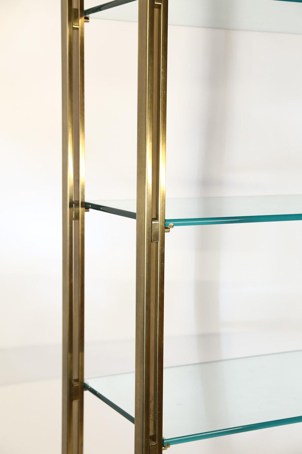 This is a beautiful Mid-Century Modern brass and glass étagère which features a solid brass frame, five original glass shelves plus a sixth original glass shelf as the top. The étagère is in original condition with normal wear from age and use. The
