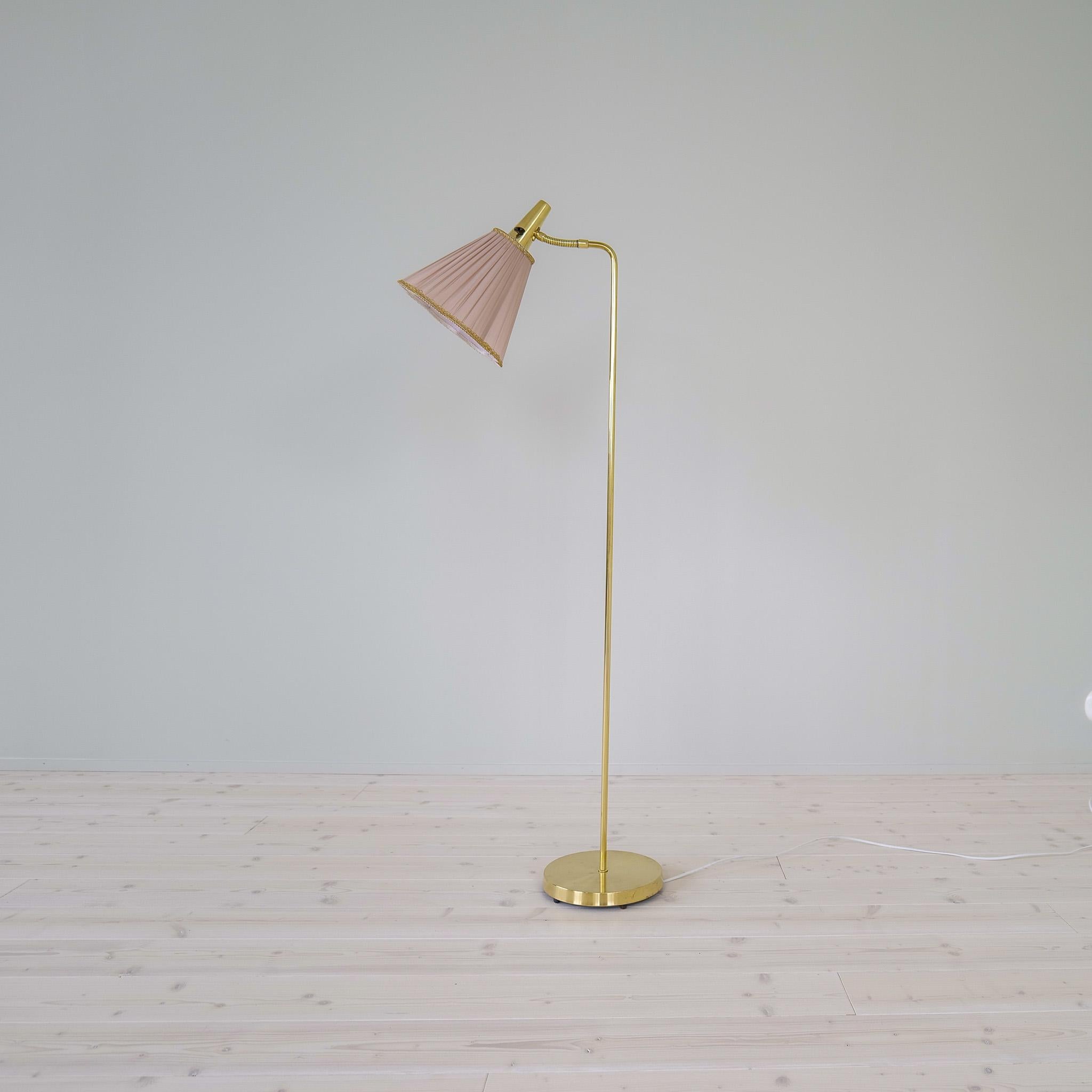 This lamp produced at Falkenbergs Belysning in Sweden during the 1960s. Made in brass with a base in cast iron. The shade with its mellow pink color works good with the brass. 

Good working condition with some dents on the foot and scratches on