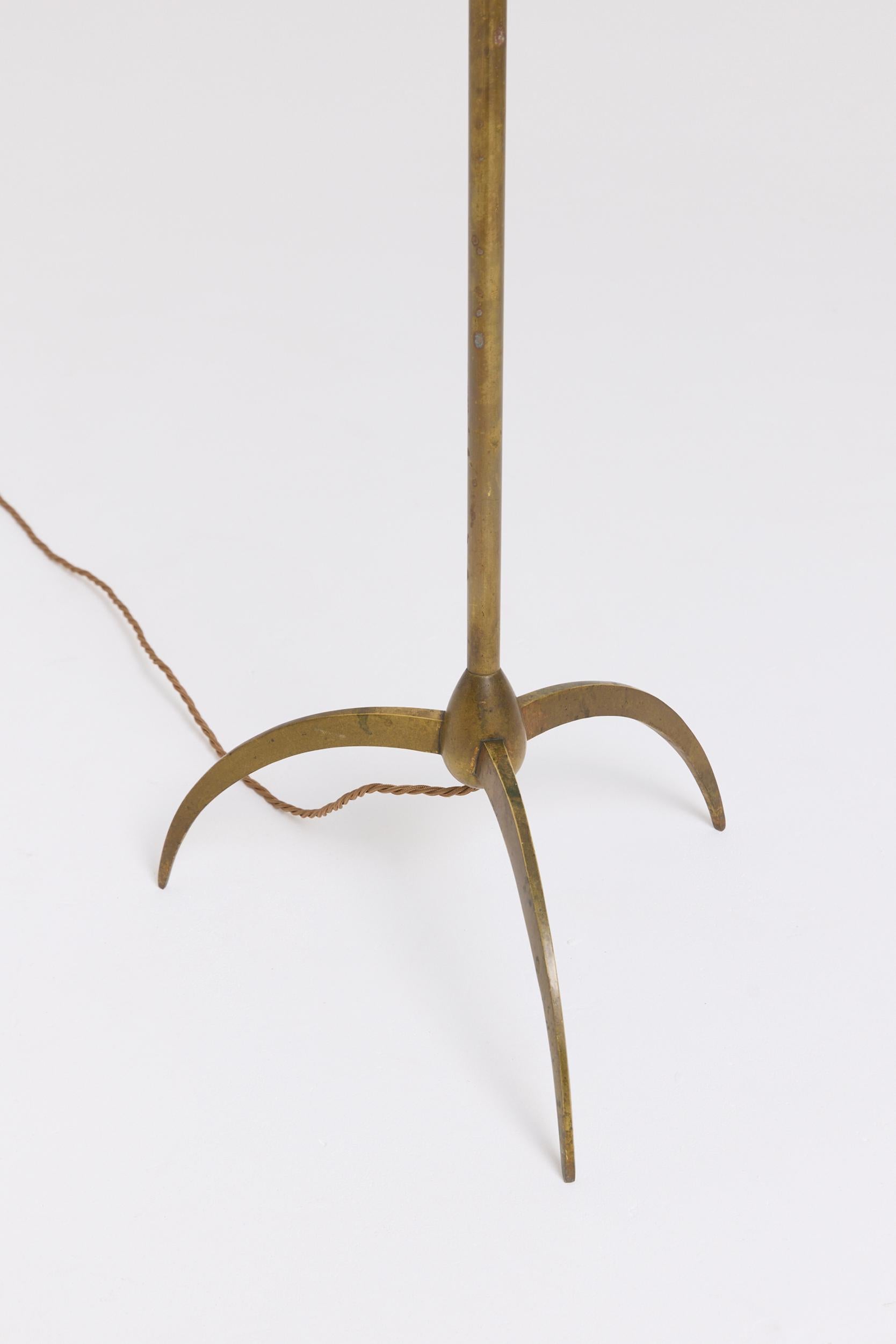 A brass tripod floor lamp
France, 1950s
With the shade: 164.5 cm high by 46 cm diameter
Lamp base only: 140 cm high by 32 cm diameter