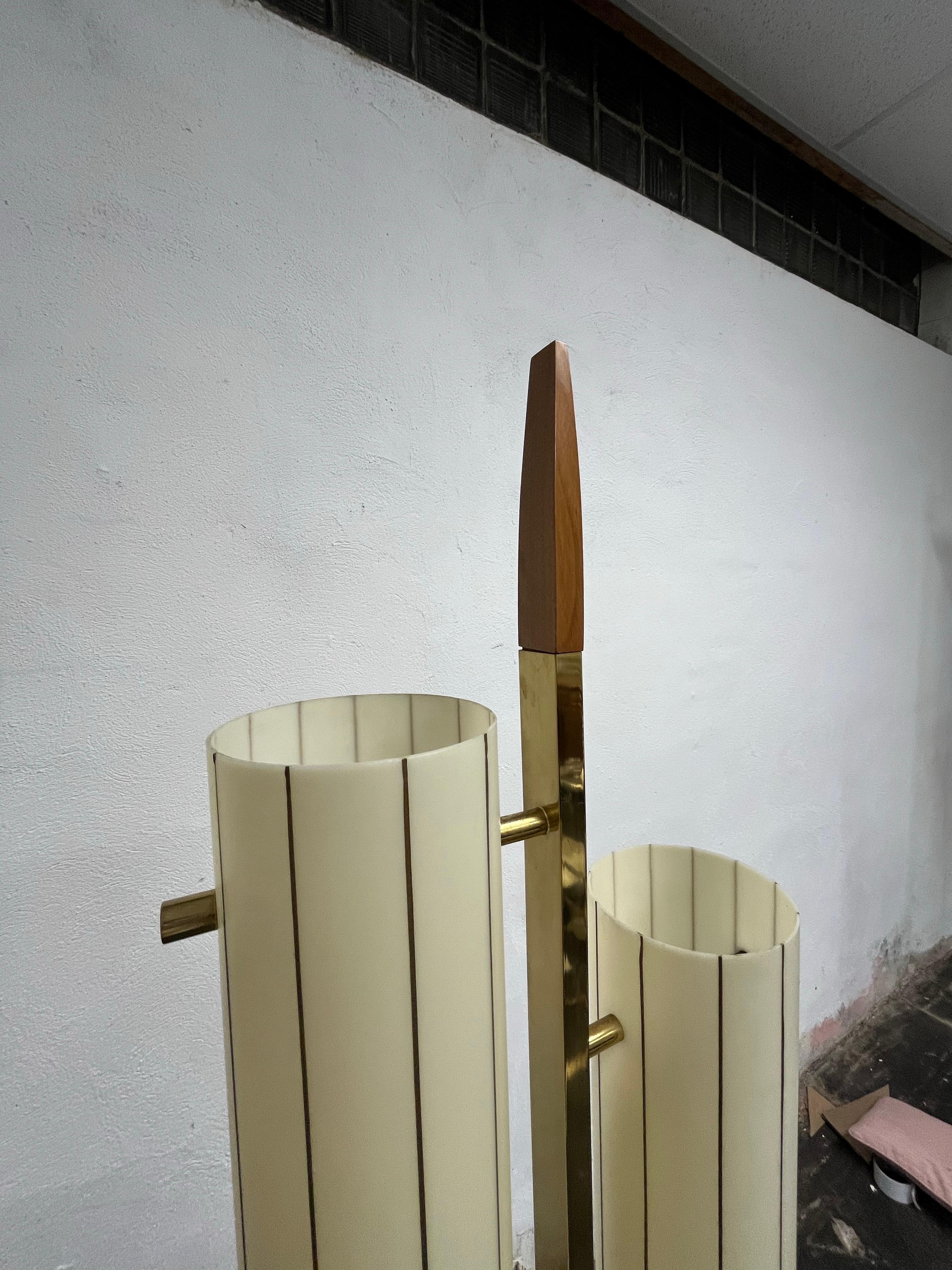 Favolosa lampada da terra della metà del secolo scorso alla maniera di Tommi Parzinger, Gerald Thurston e Laurel Lamp. In ottone con accenti in legno. 2 paralumi cilindrici in acrilico fissati con robusti supporti in ottone. Un design superbo che