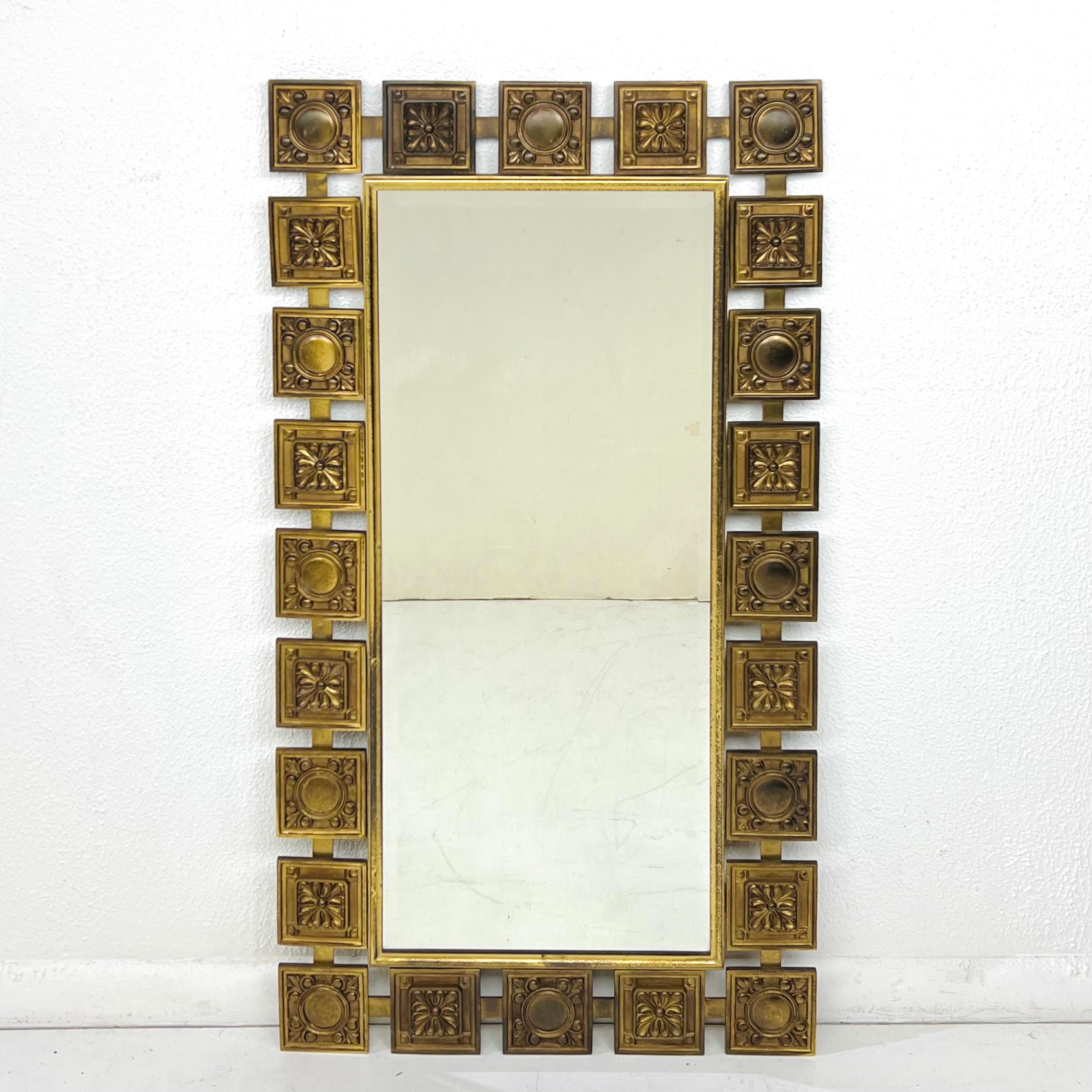 This midcentury modern mirror is framed by alternating brass squares of two different designs, joined by a flat metal stretcher. This is a heavy and unusual piece, circa 1950s. Very good vintage condition.