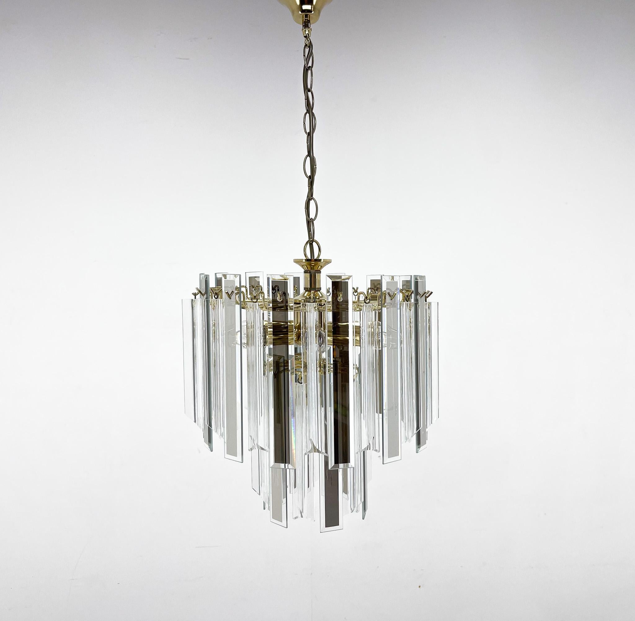 Midcentury brass chandelier with glass and Lucite. Each glass pendant features beveled edge with a mirror center. Lucite strands are three sided. Beautifully illuminating and reflecting light. There are some imperfections (see photo).