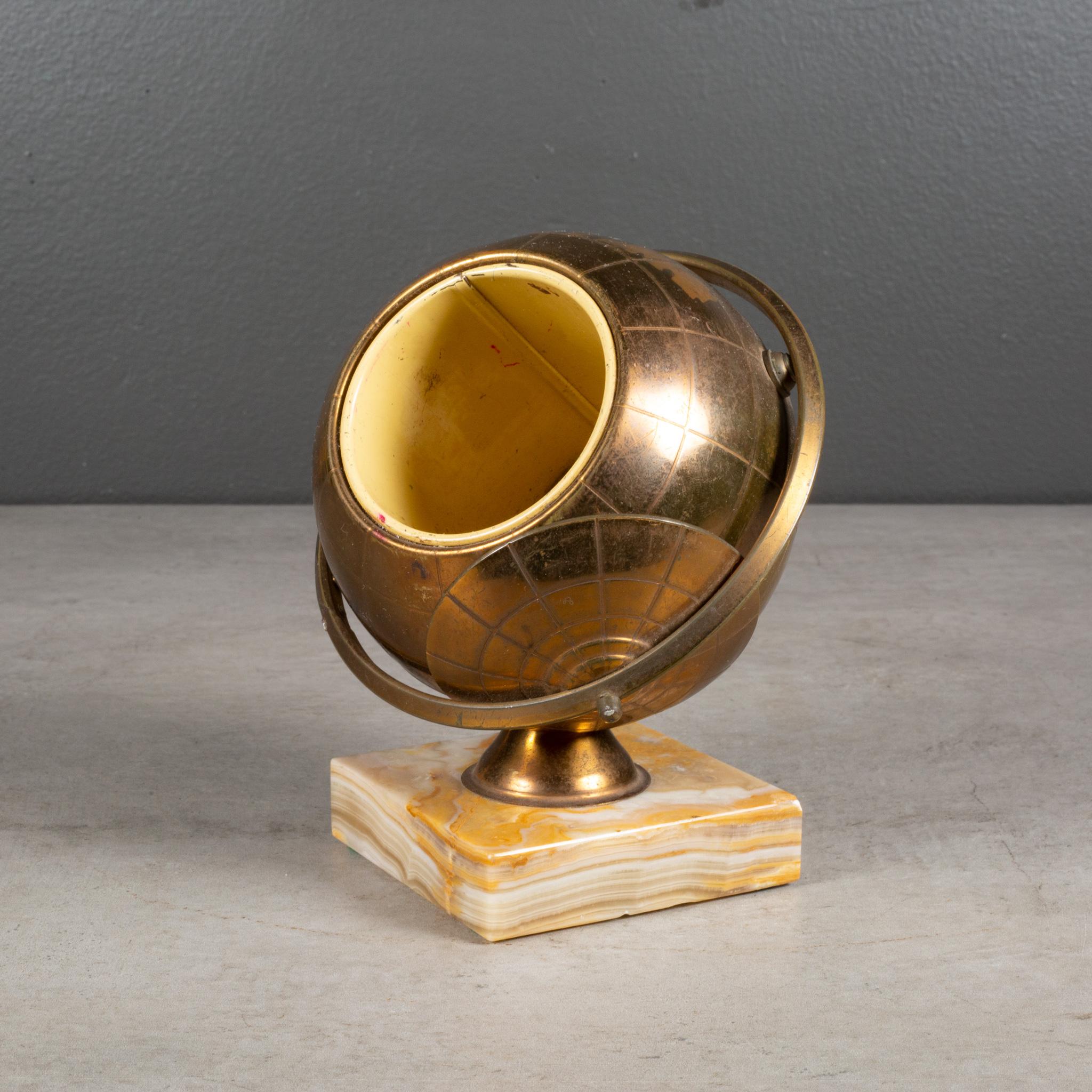 ABOUT 

An original mid-century brass cigarette holder mounted on a solid marble base. The lid slides open on the globe's axis to reveal a metal interior designed to hold cigarettes. This piece has retained its original finish and has the
