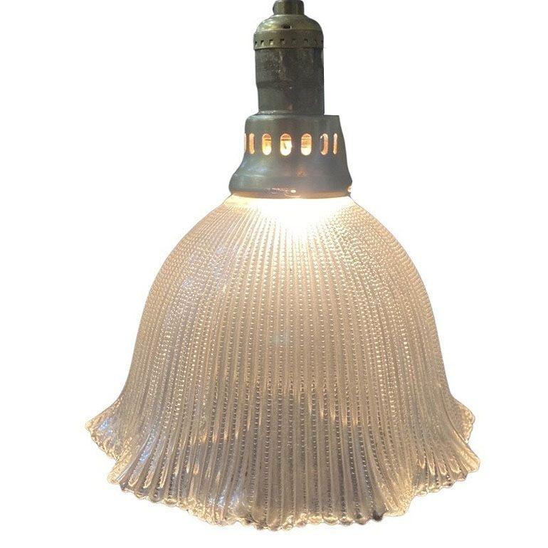 Bellissima lampada a sospensione da soffitto in ottone del Mid-Century con paralume a campana in vetro Holophane. Il vetro Holophane è un tipo di apparecchio di illuminazione caratterizzato da un paralume in vetro con un design prismatico che