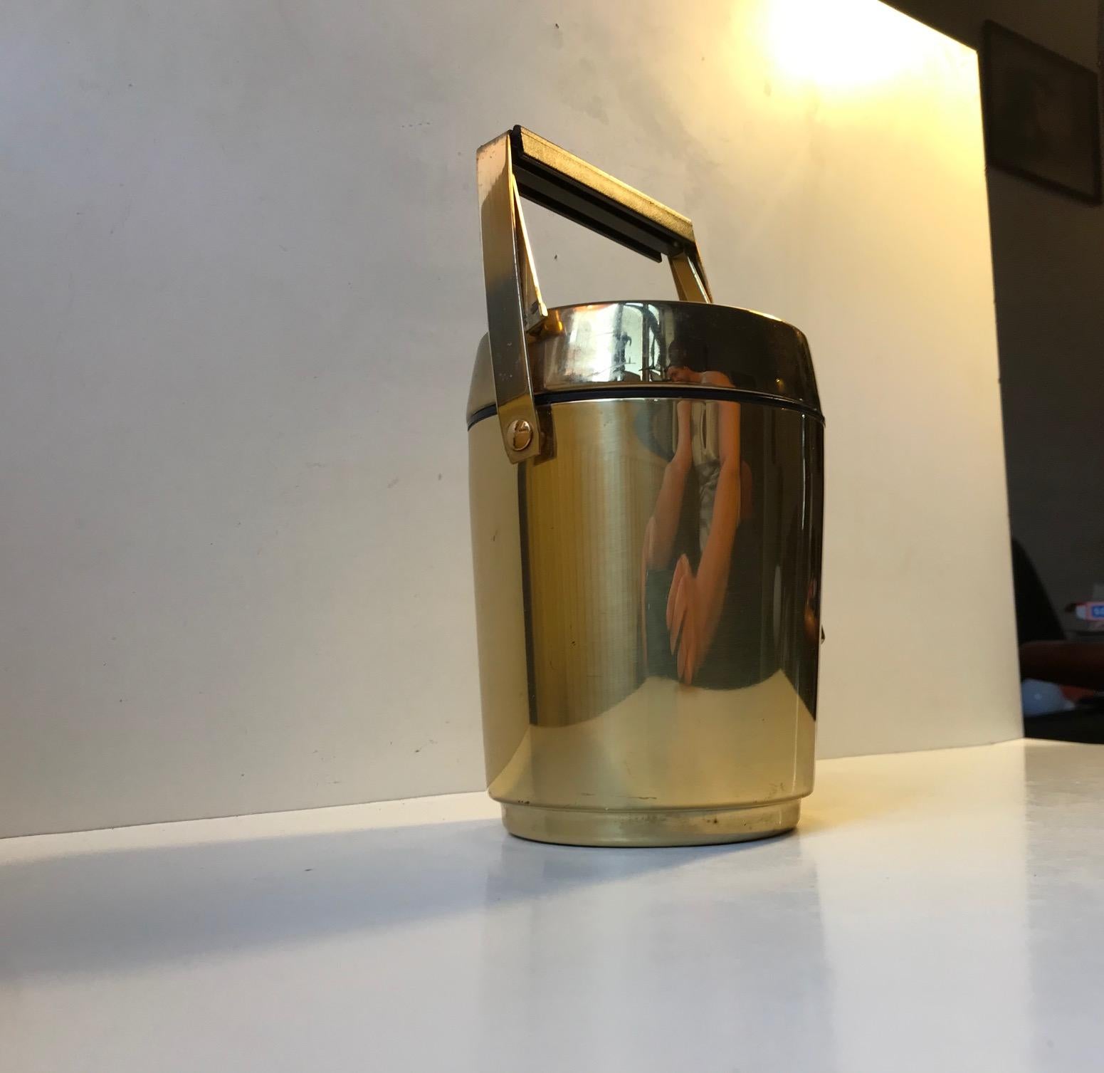 A solid brass ice bucket with built in thermos and matching ice tong. Everything is operated with the handle that has a built-in lid-opener. Its imprinted Alfi Western Germany beneath its base.