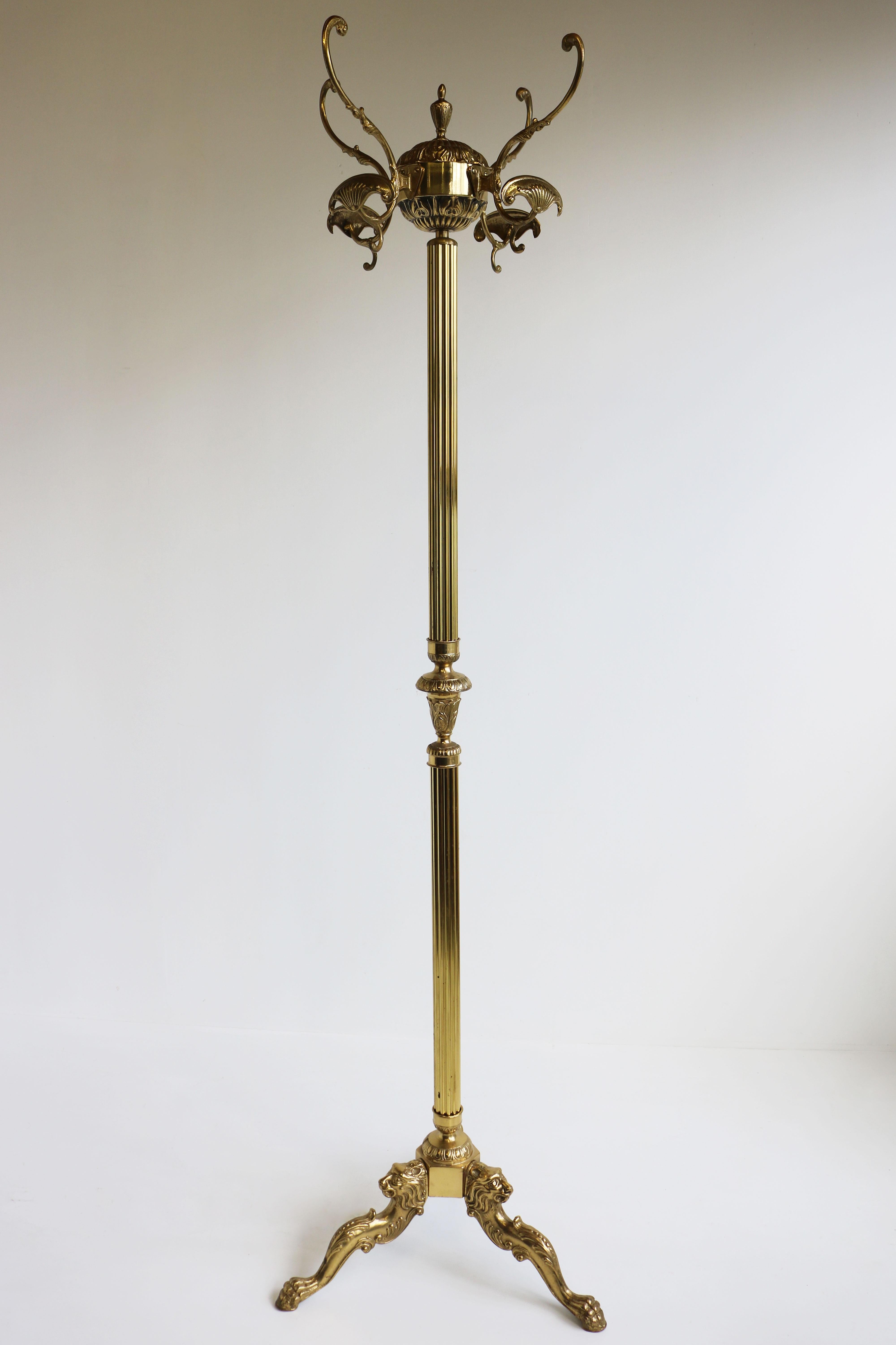 A stunning and very well made mid-century free standing Italian ornate brass coat stand from the 1950s. 
With turnable crown and casted brass hooks, and three lightly curved legs are embellished with lions heads and end in the lions' paws. This