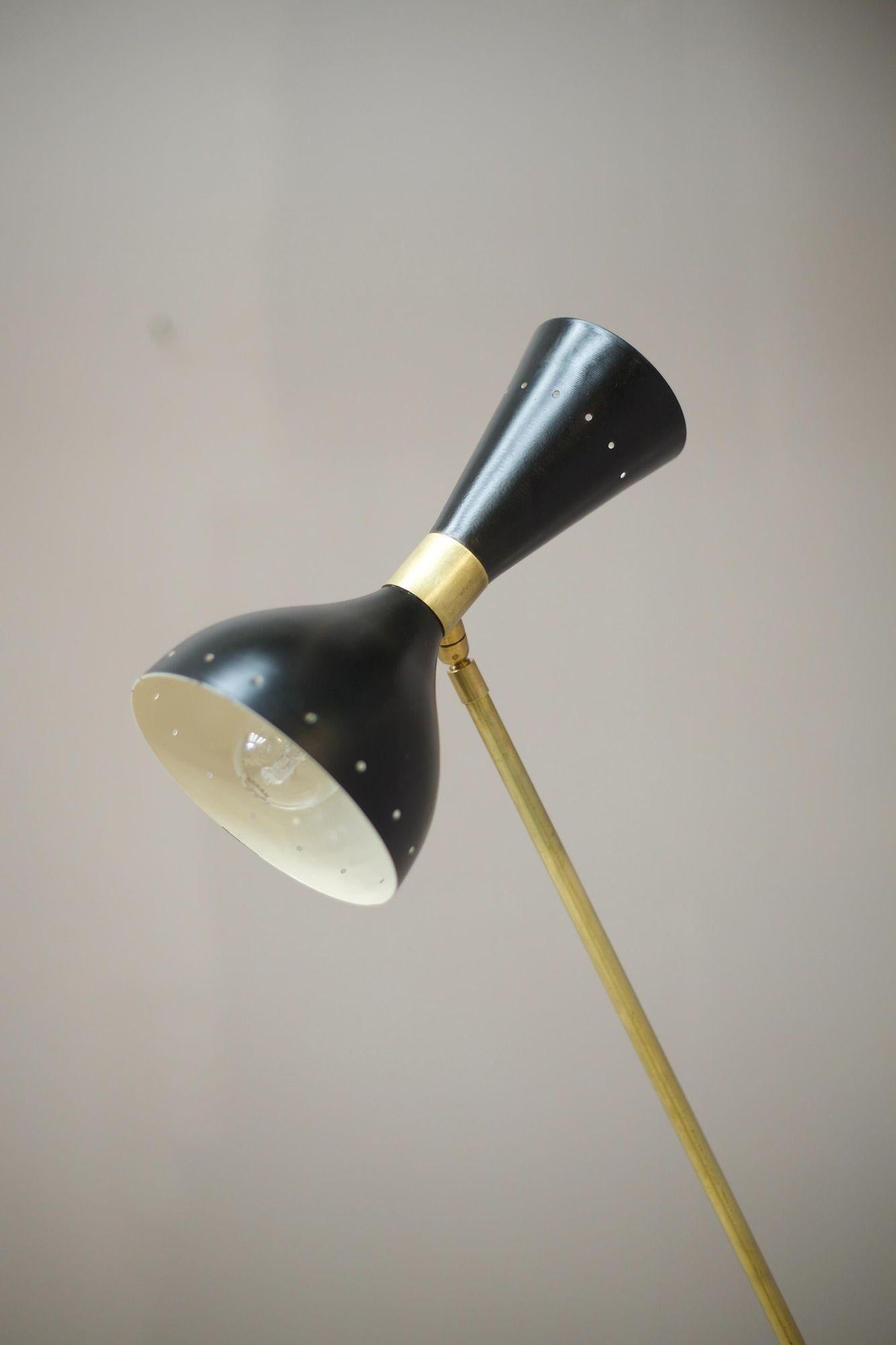 This is a very stylish mid century Italian floor lamp by Stilnovo. Made from brass with a black shade. The overall design is effortlessly stunning with its minimal profile and sleek nature. The support arm adjusts up and down and the lamp head can