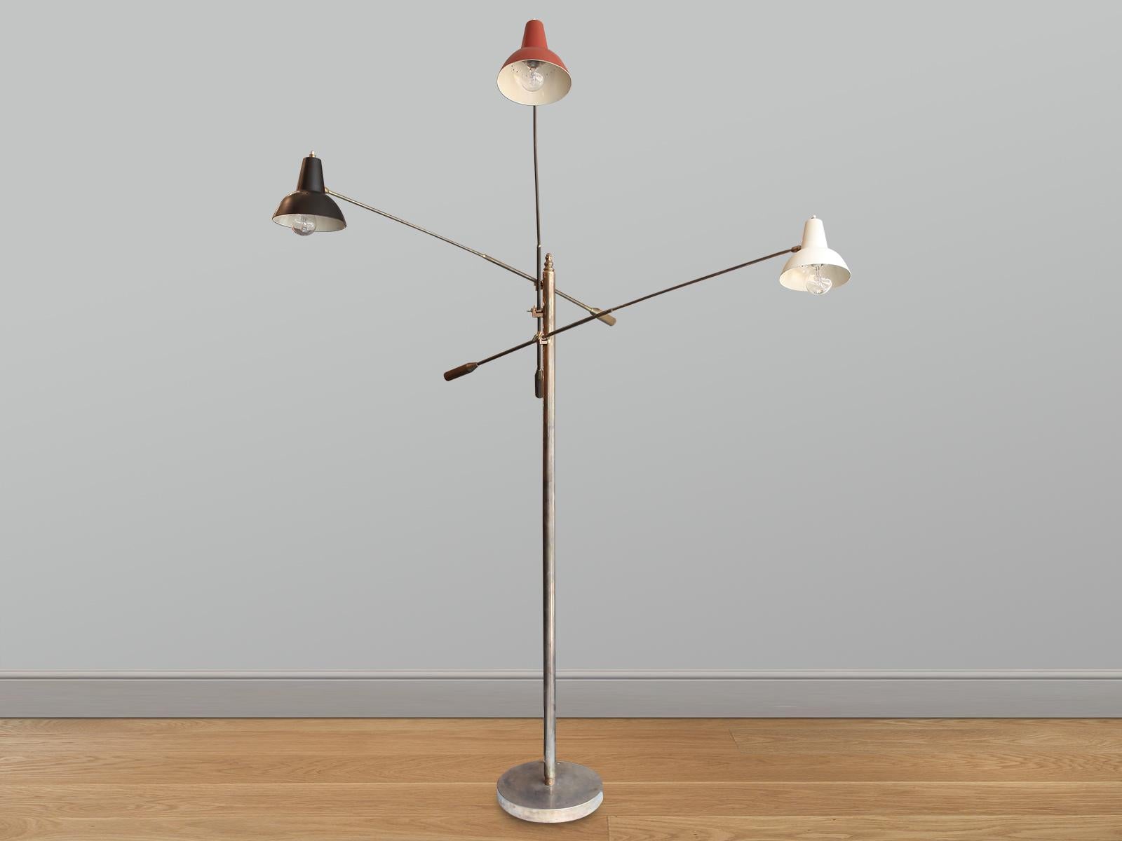 A large Triennale floor lamp in brass with three painted shades in red, black and cream. Each shade having  a pivotal knuckle and light switch.
