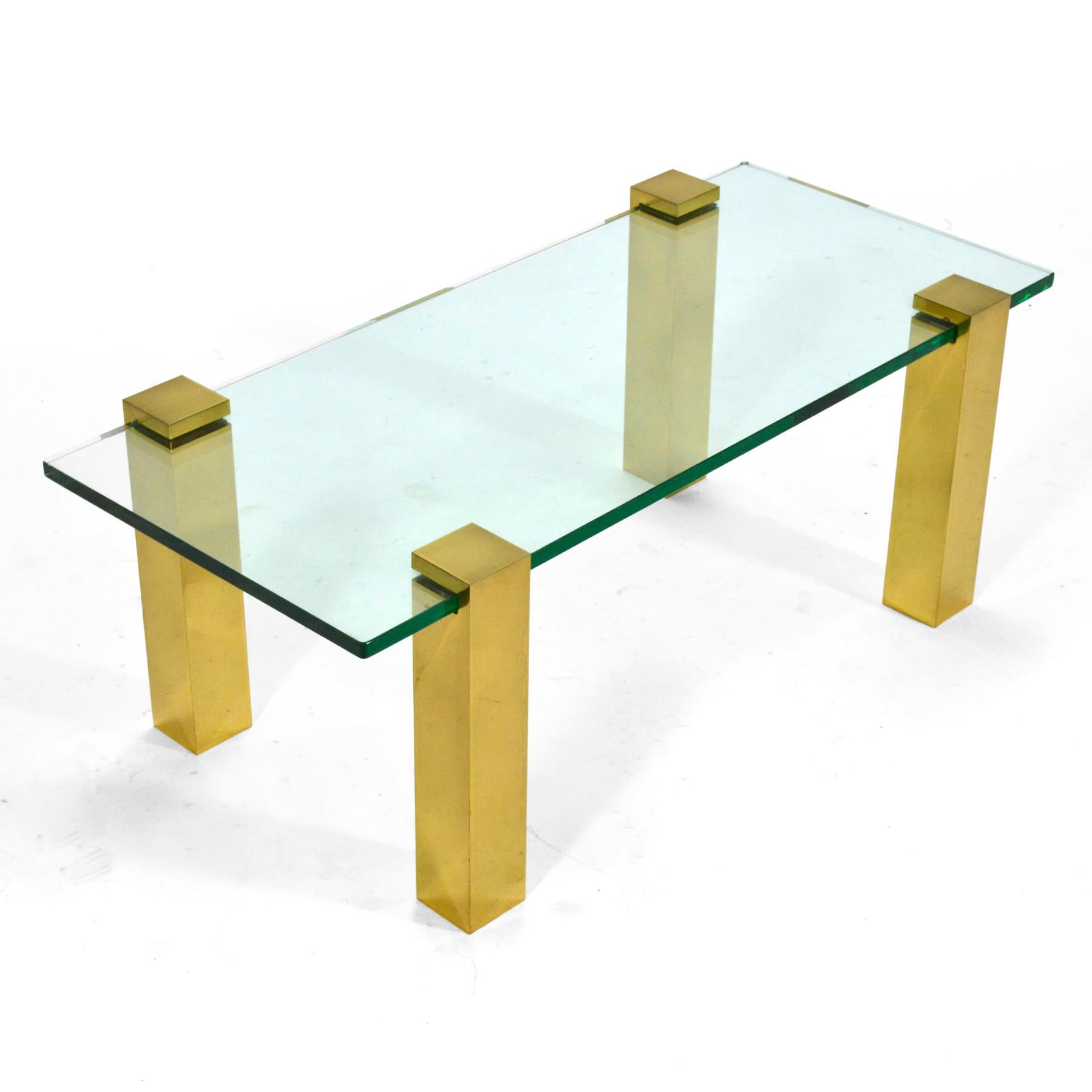 This handsome and versatile minimalist design has four brass legs which attach via pressure to a glass top. They can be configured different ways: in the corners, in the center of each side– and the table can easily change size by replacing the