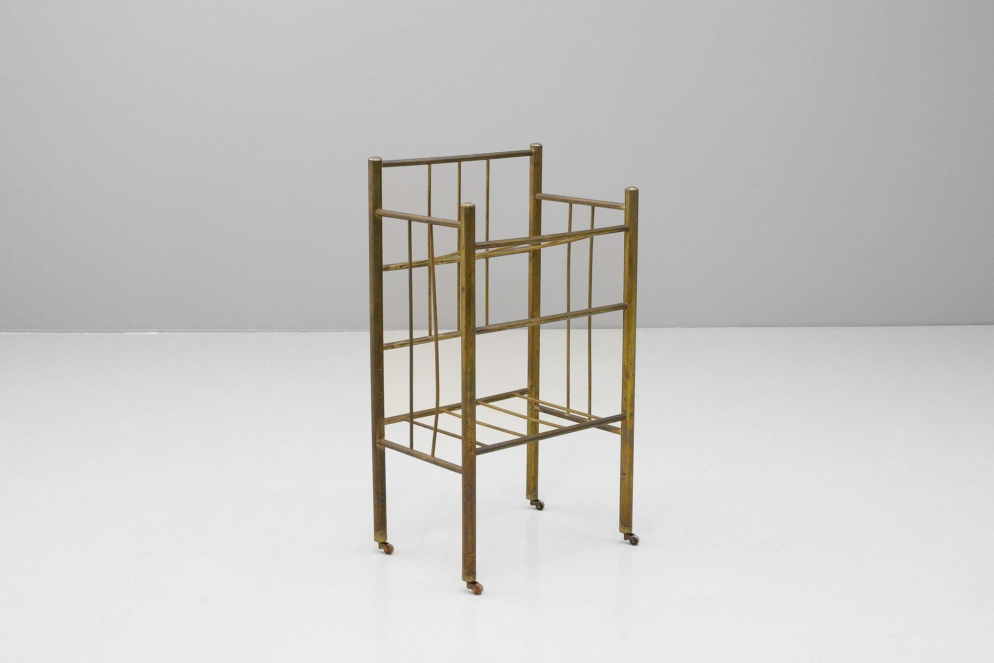 Portariviste tubolare di metà secolo in ottone con ruote originali. Bella patina sull'ottone.