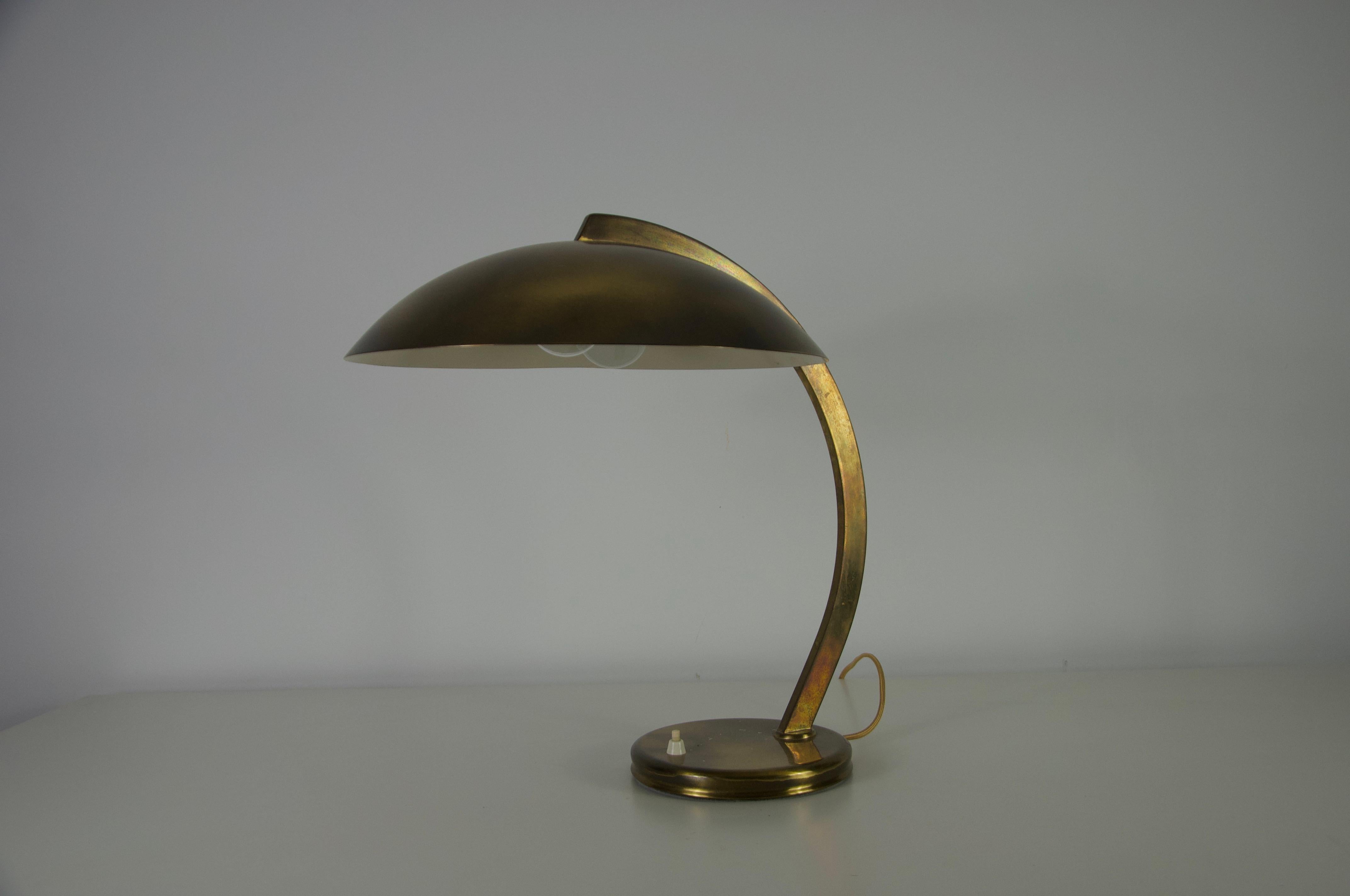 Questa lampada da tavolo in ottone del Mid-Century, originaria della Germania degli anni '60, incarna l'eleganza classica e il design funzionale dell'epoca. La lampada è caratterizzata da un grazioso braccio in ottone arcuato che si estende da una