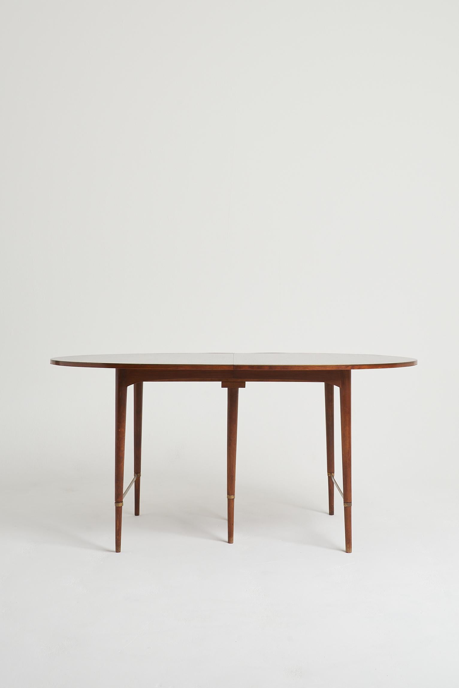 A mahogany and brass extending dining table by Paul McCobb, for H. Sacks & Sons “Connoisseur” line.
USA, Circa 1950
The minimum (without any extra leaf) is 158cm long.
Each leaf is 35 cm wide and there are five of them. So the table can extended to