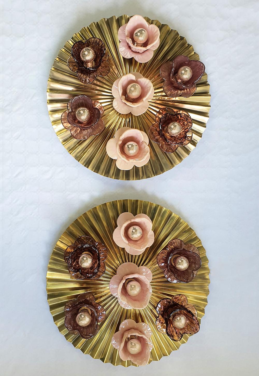 Pair of large round and flat brass & Murano glass wall sconces or flush mounts, Mid Century Modern, Italy circa 1970s.
The vintage pair is made of a round , flat, pleated brass base, and seven hand blown Murano glass flowers, each nesting one