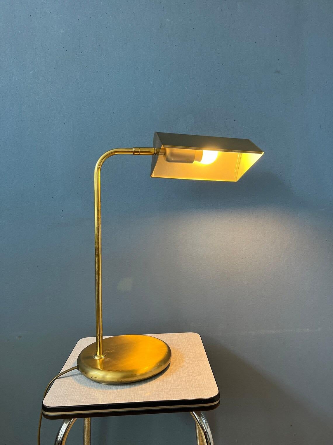 Vintage brass desk lamp with adjustable shade. The shade can easily turned in different directions, see pictures. The lamp requires an E27 lightbulb and currently has an EU-plug.

Additional information:
Materials: Glass, metal, wood
Period: